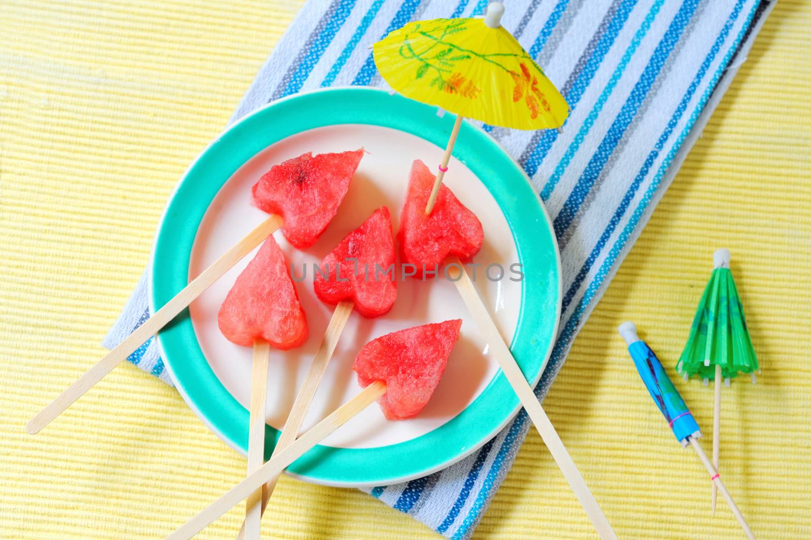 fruit pops of watermelon in heart shaped shoot in studio. watermelon heart as lollipop