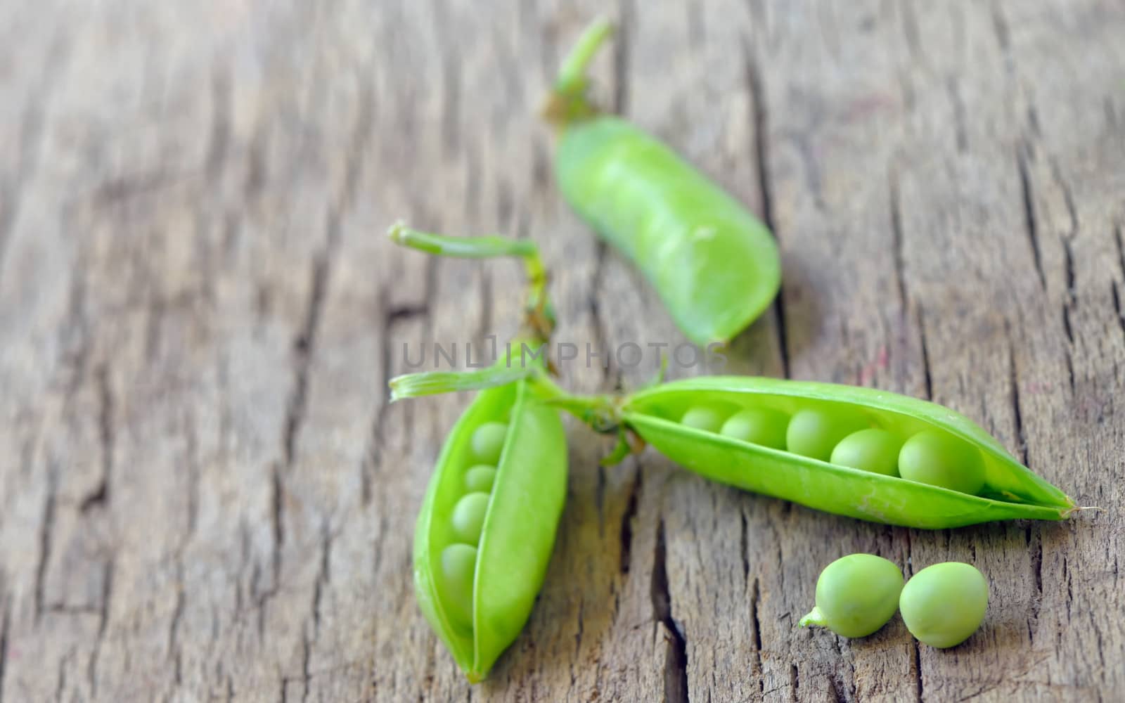 Fresh green peas on an old wooden background by mady70