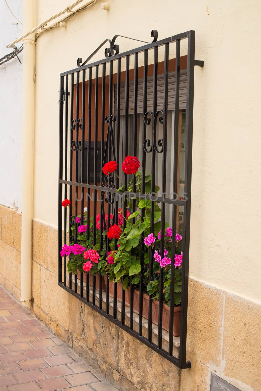 Charming old Andalusian village window with geraniums on the sill