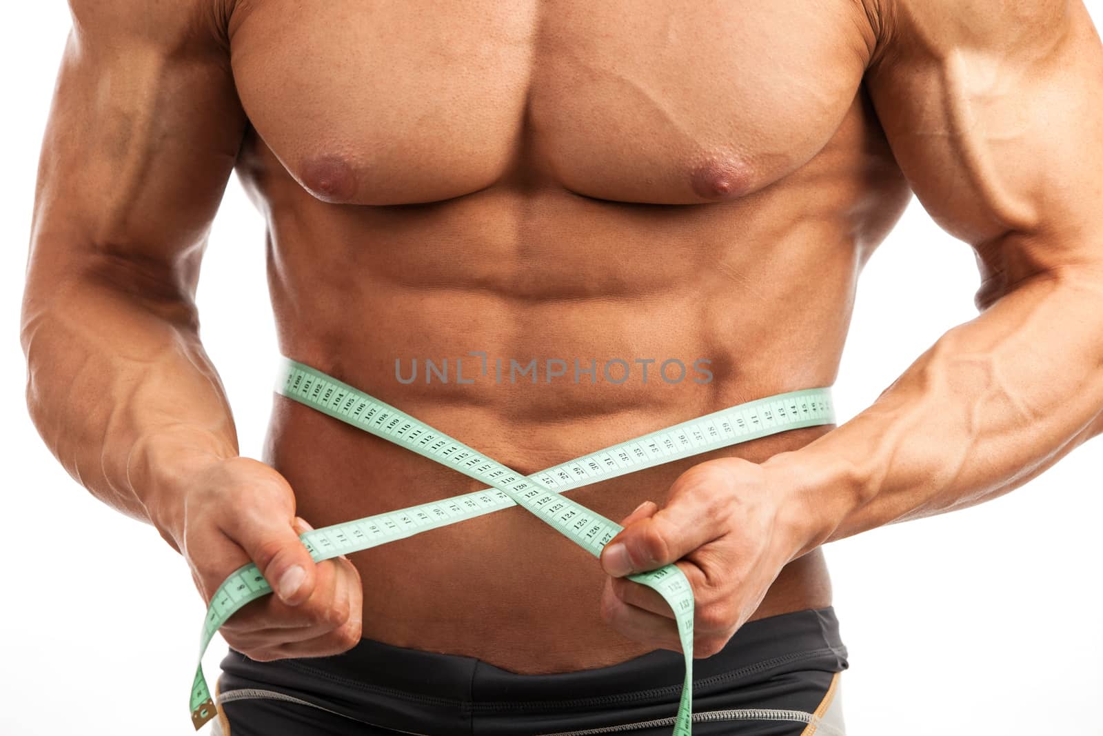 Cropped view of young muscular man with measuring tape