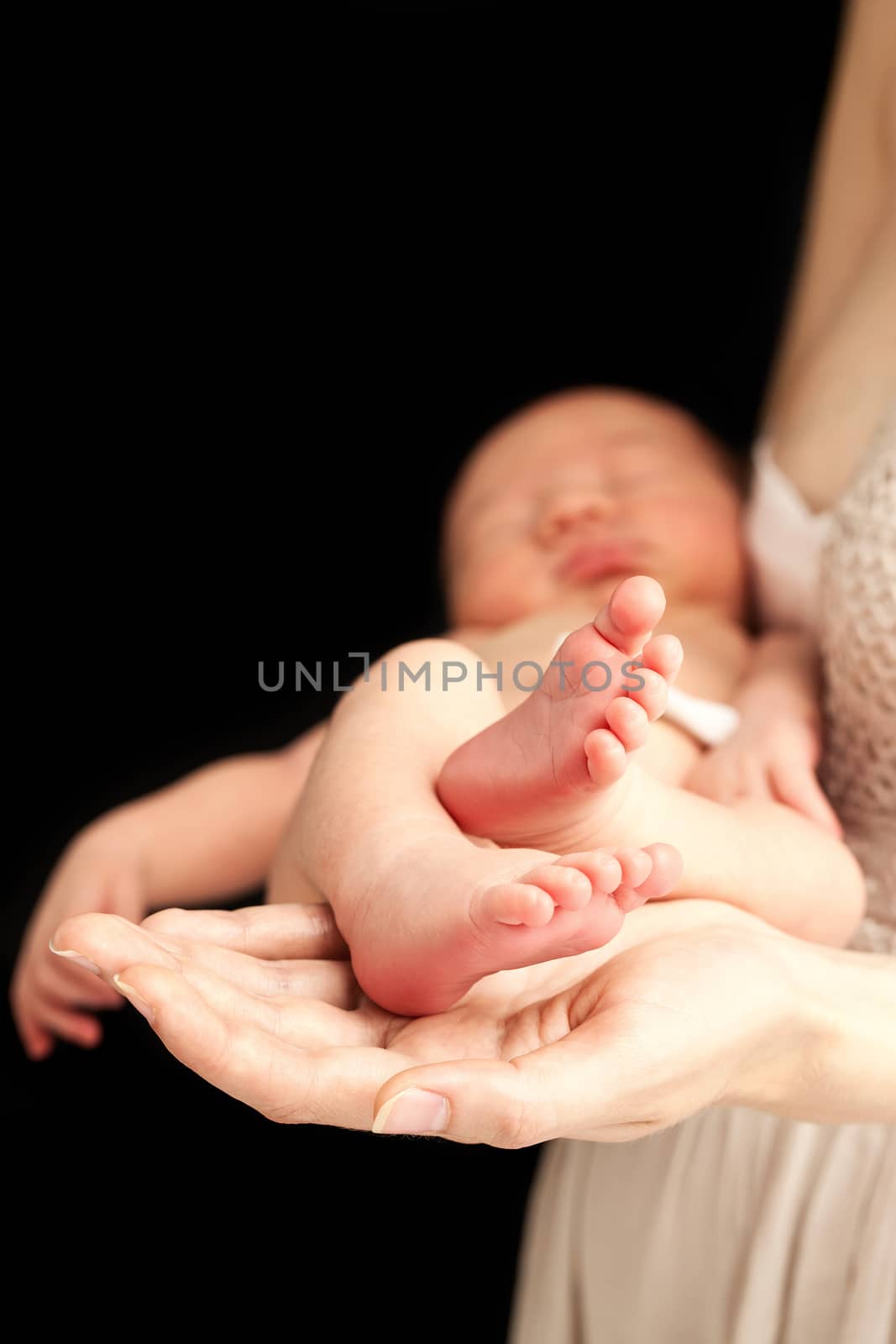 Young caucasian woman holding newborn son over black by photobac