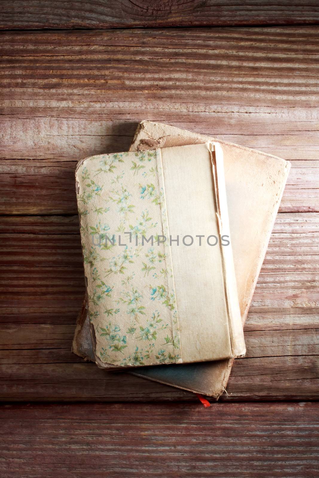 Aged books on a rustic wooden table by melpomene