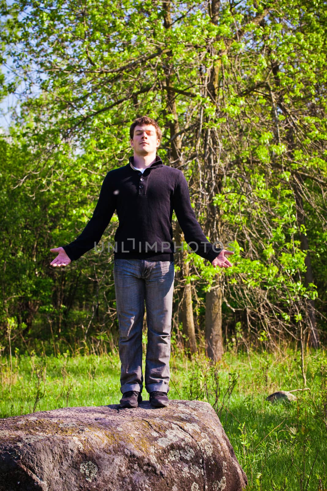 Man standing up on the rock in the forest