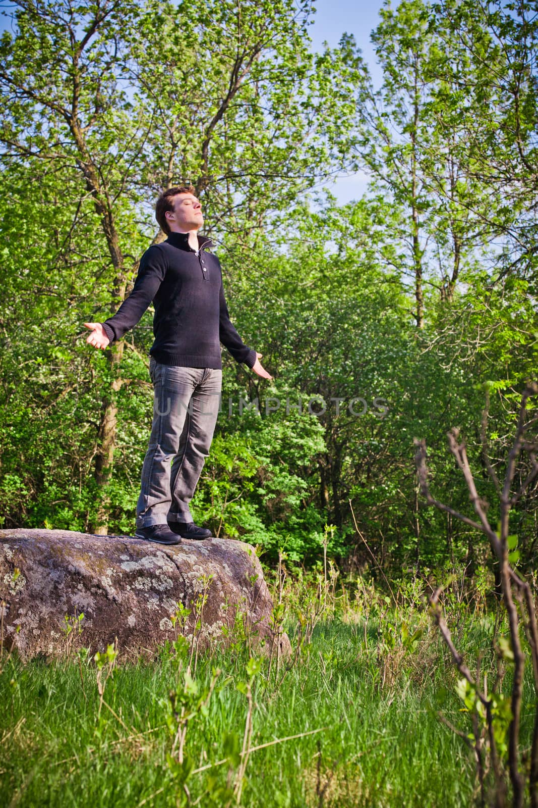 Man standing up on the rock in the forest