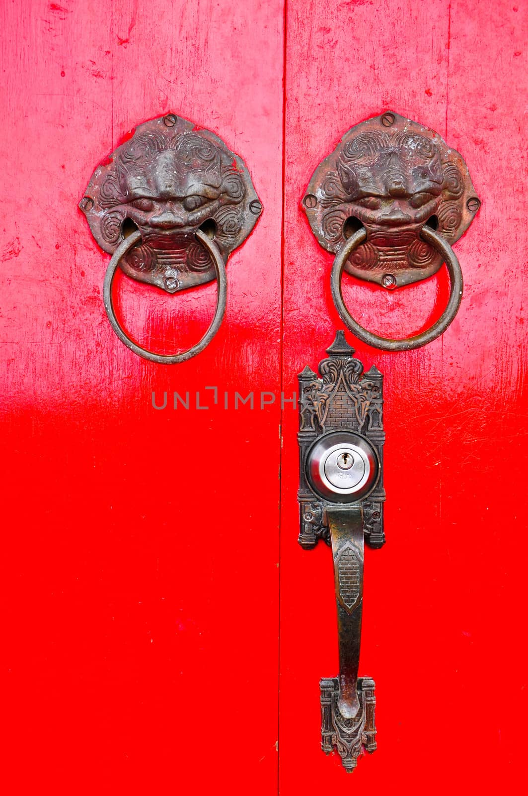 Red chinese door with a lion/dragon head.