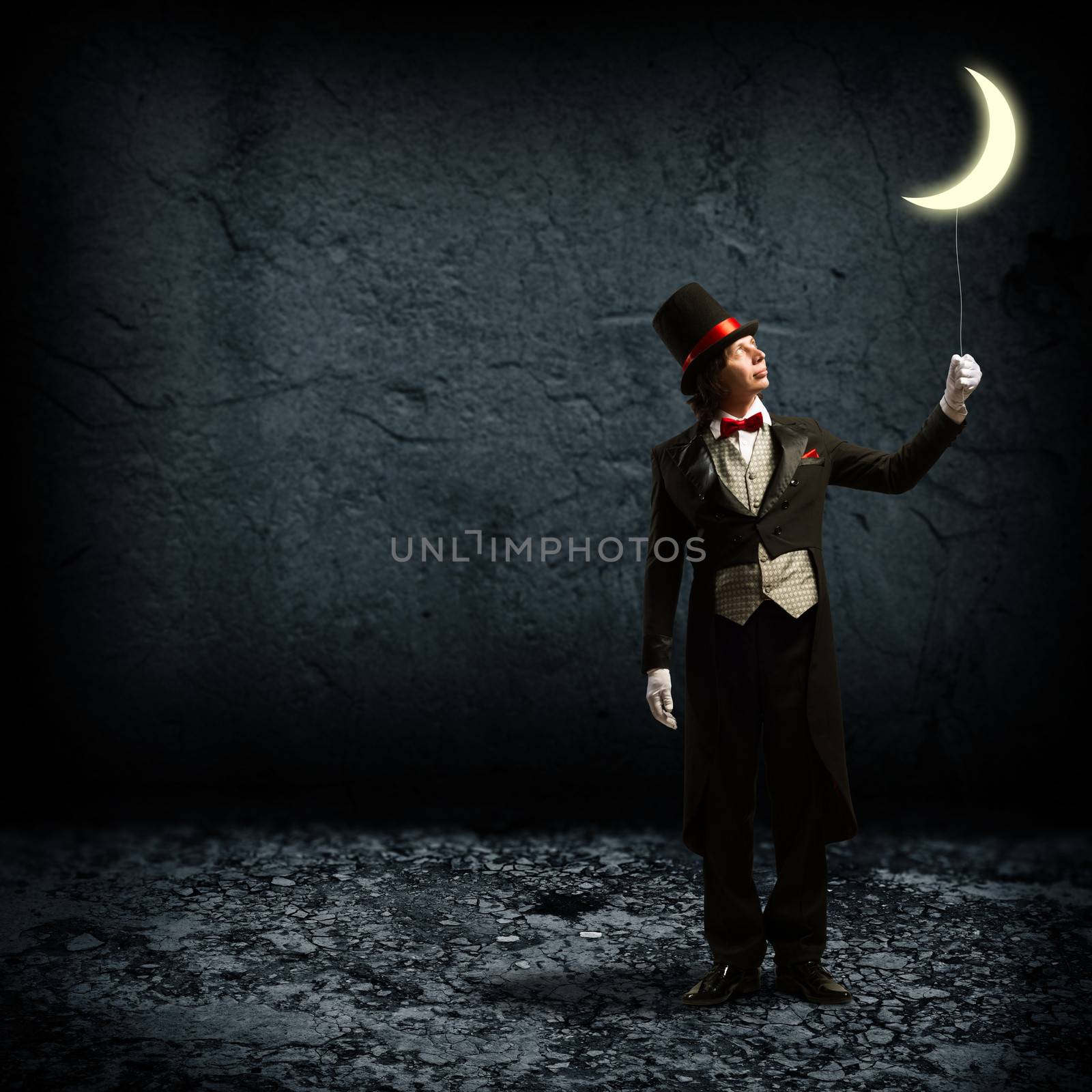 magician in top hat and tie, holding a glowing moon on a string