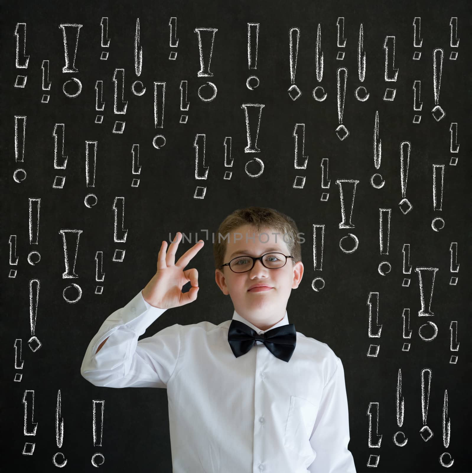 All ok or okay sign boy dressed up as business man with chalk exclamation marks on blackboard background