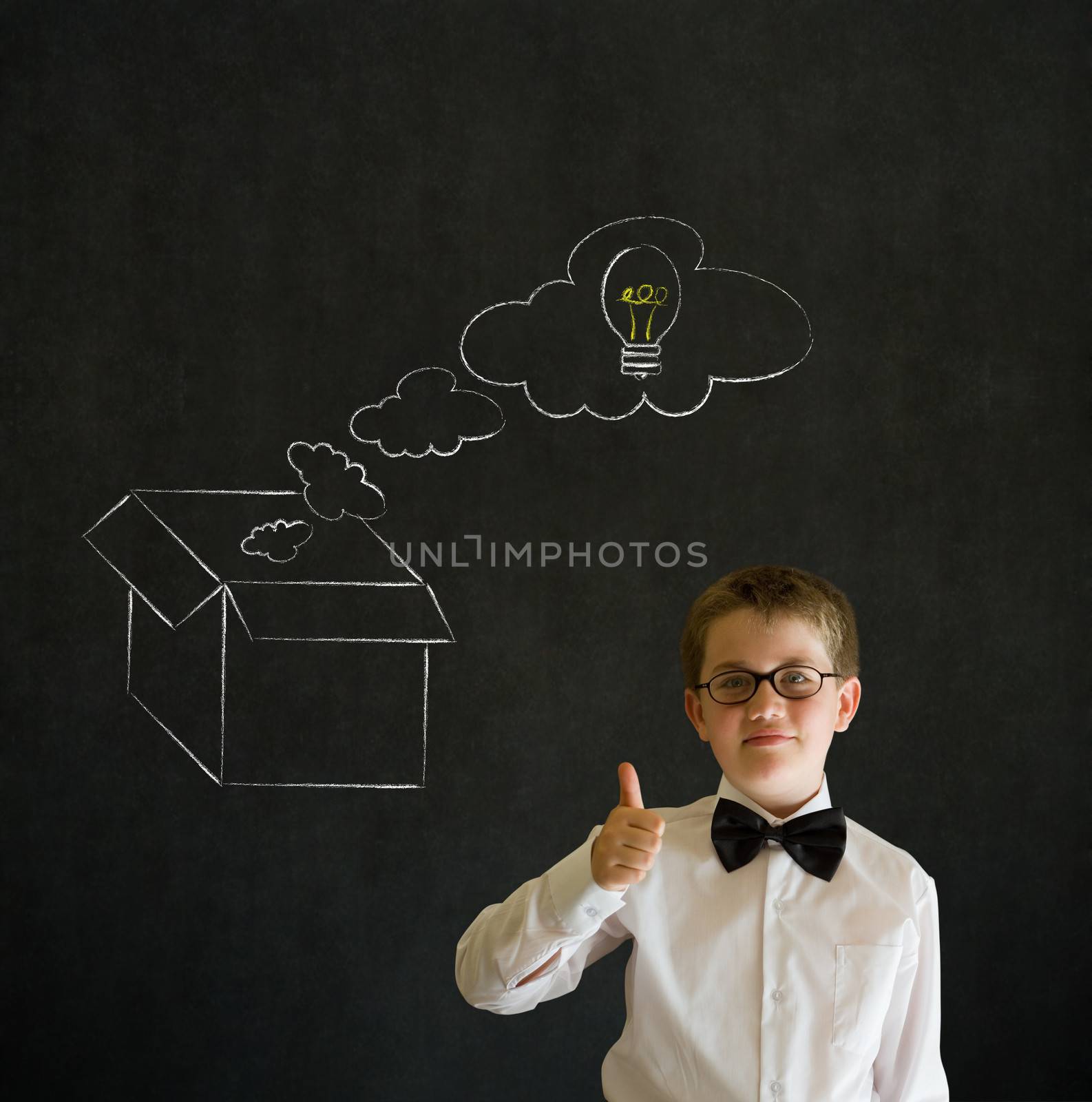 Thumbs up boy dressed up as business man with chalk thinking out the box concept  on blackboard background