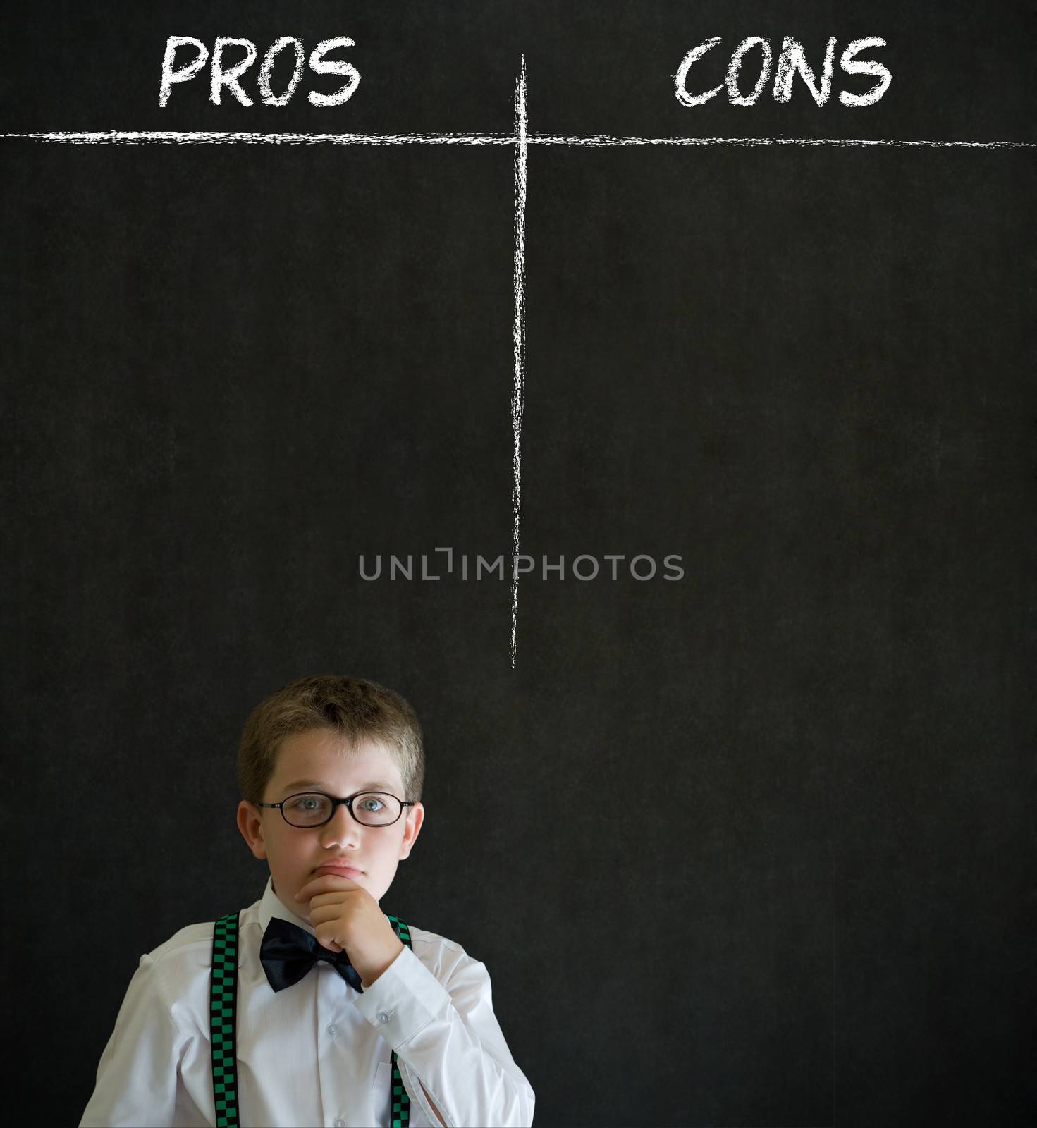 Thinking boy dressed up as business man with chalk pros and cons decision list on blackboard background