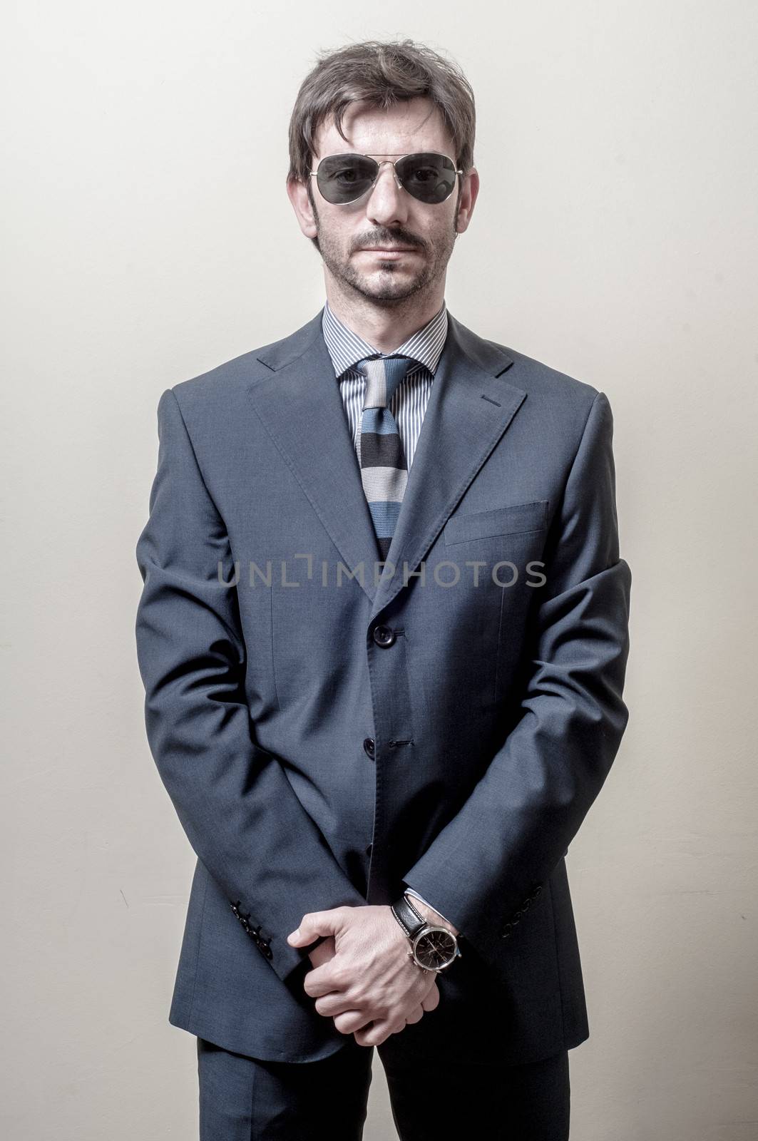businessman serious with sunglasses on gray background