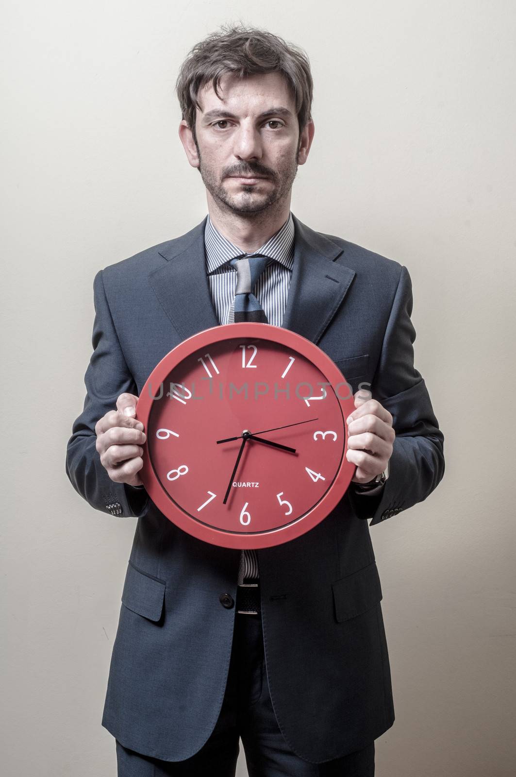 businessman with clock on gray background