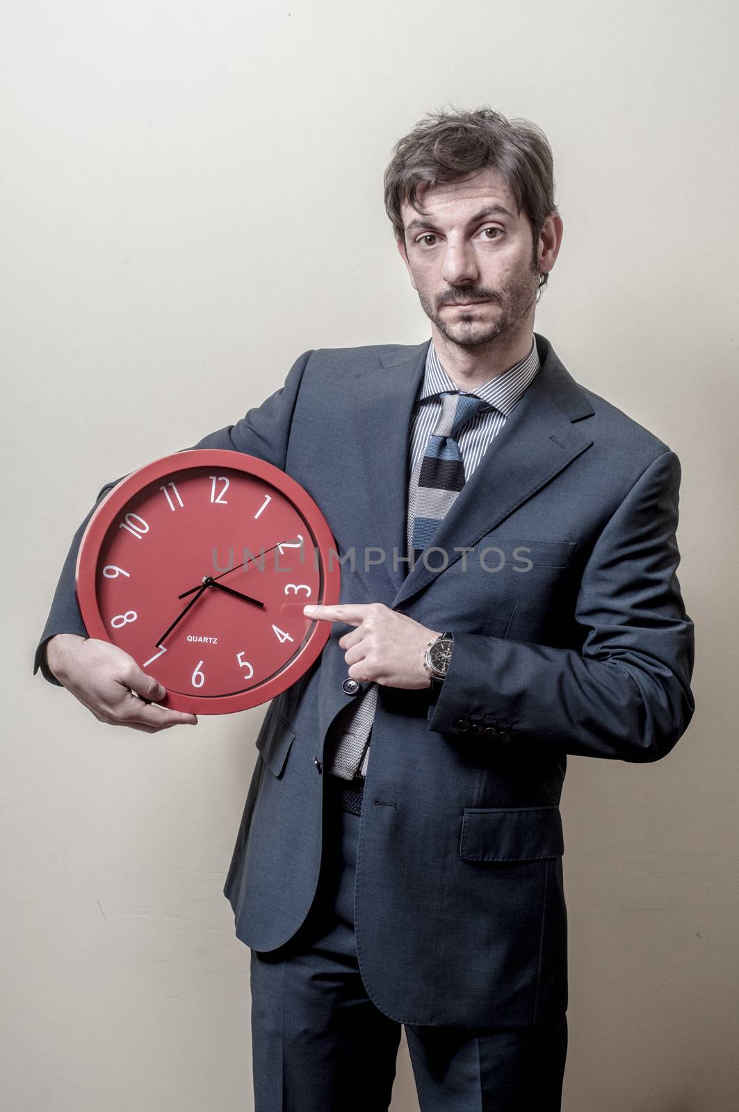 businessman pointing clock on gray background