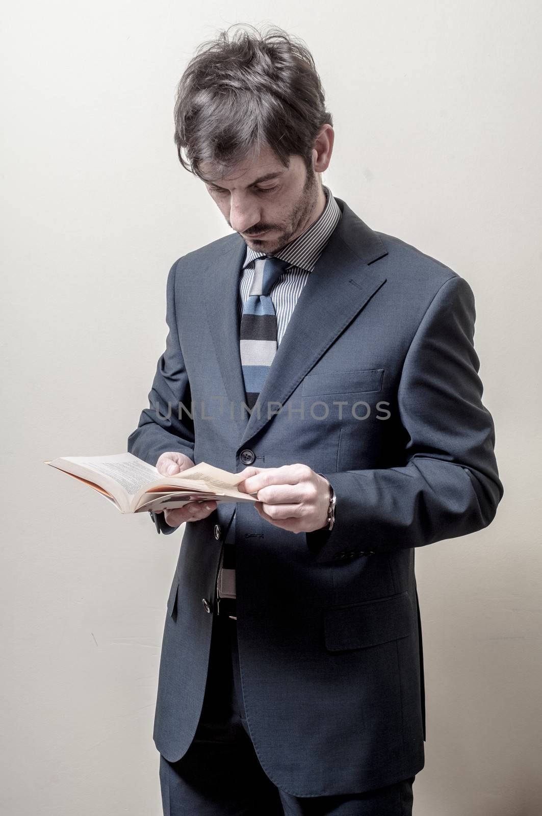 businessman reading book on gray background