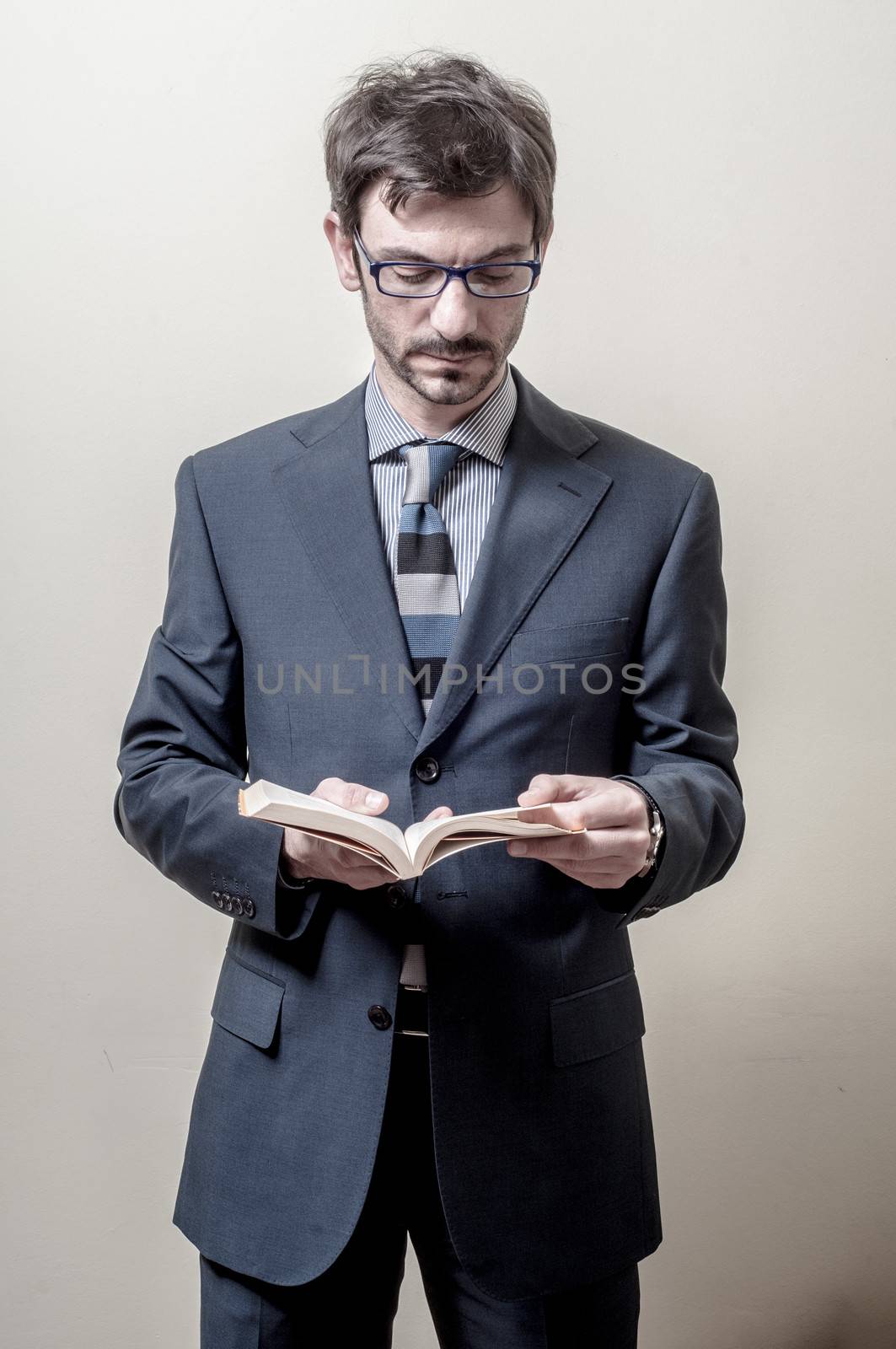 businessman reading book on gray background