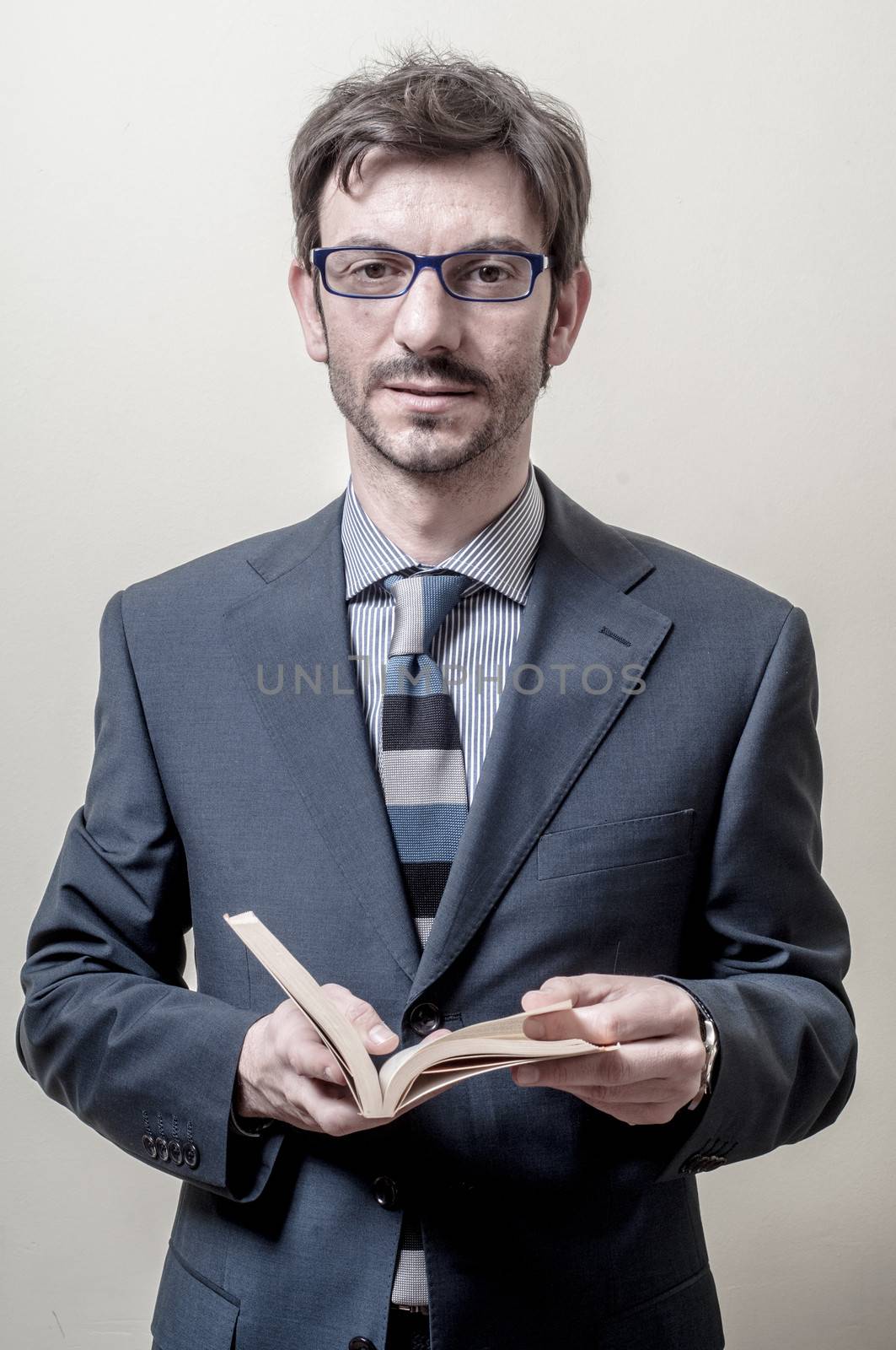 businessman reading book on gray background