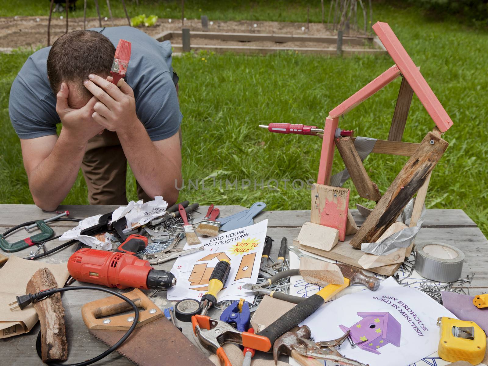 A man is frustrated and angry at building a bad birdhouse.