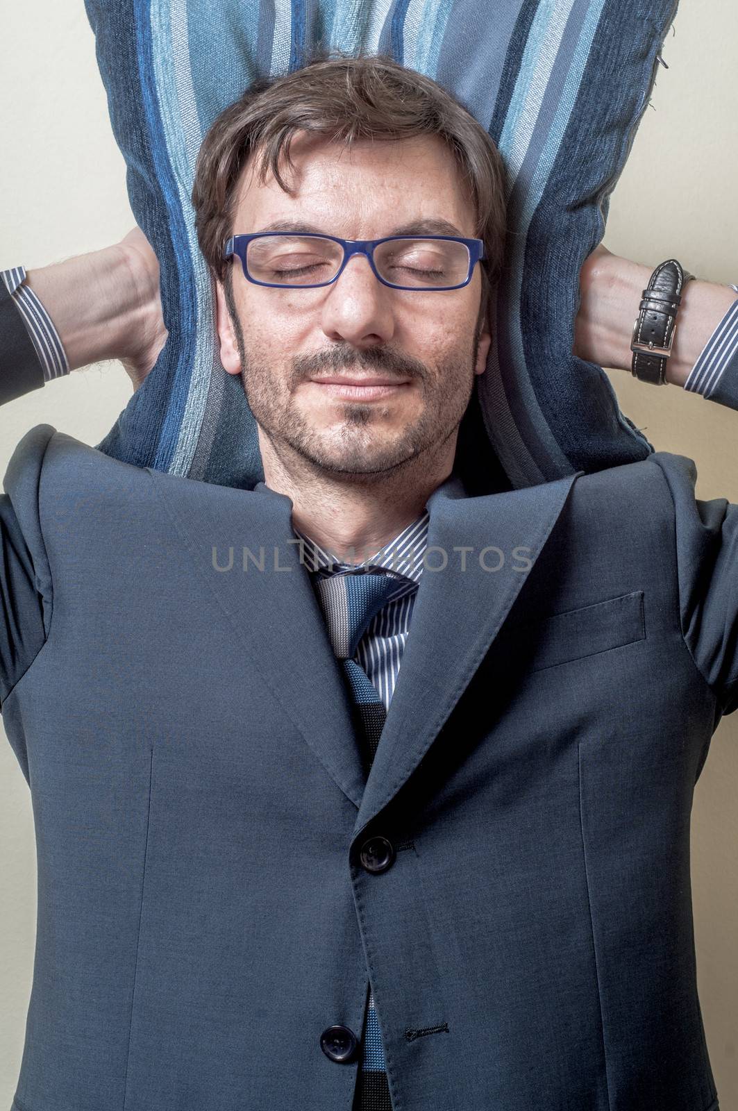businessman sleeping on pillow on gray background