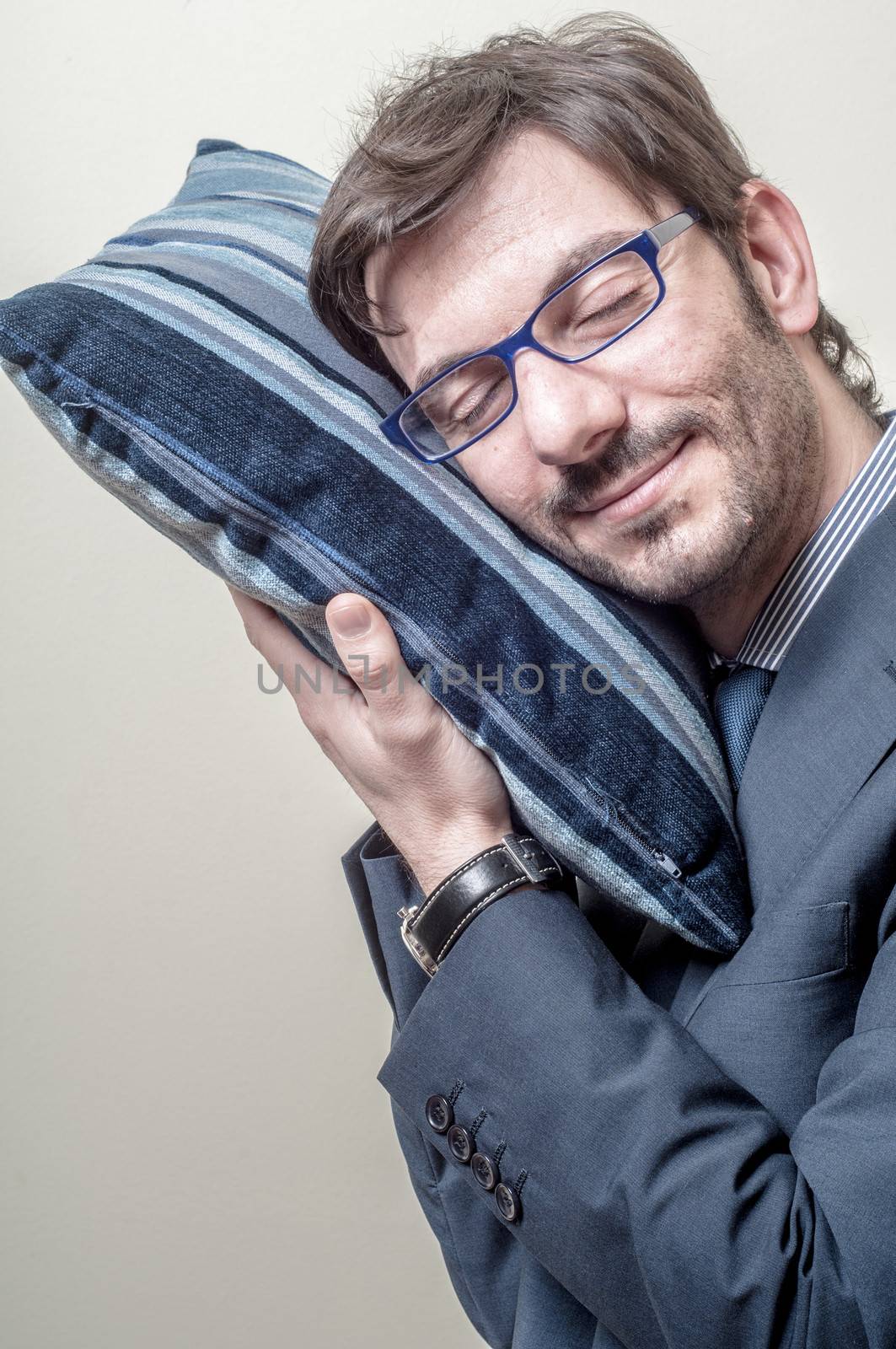 businessman sleeping on pillow on gray background