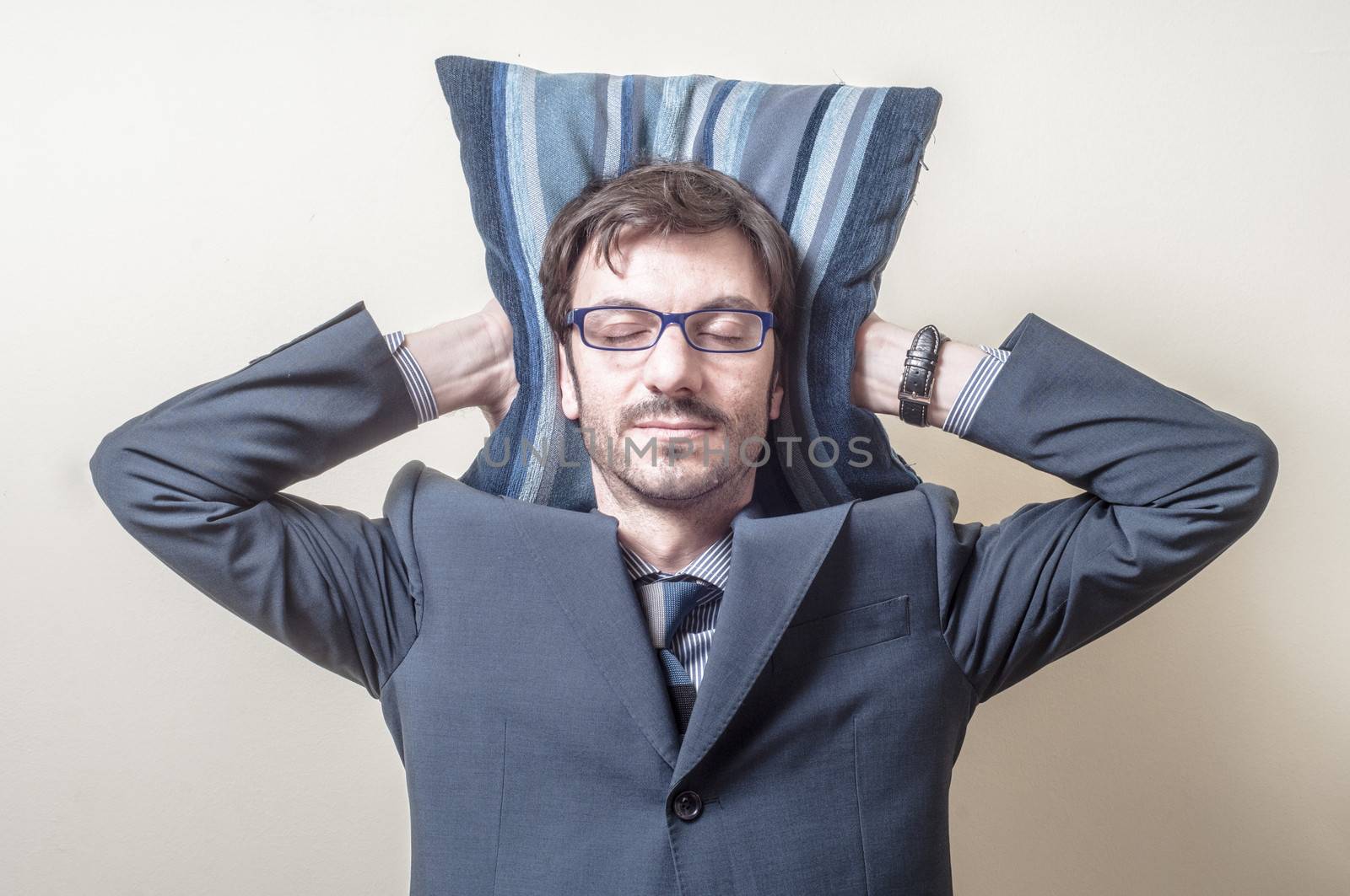 businessman sleeping on pillow on gray background
