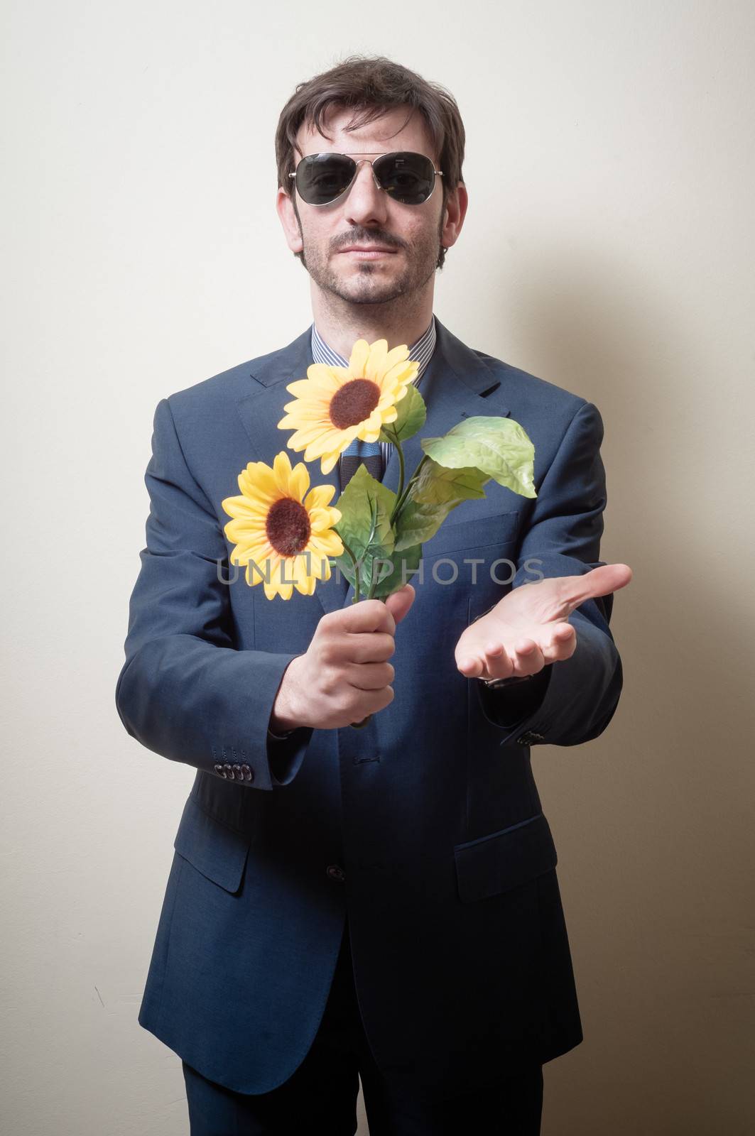 elegant man with daisies on gray background