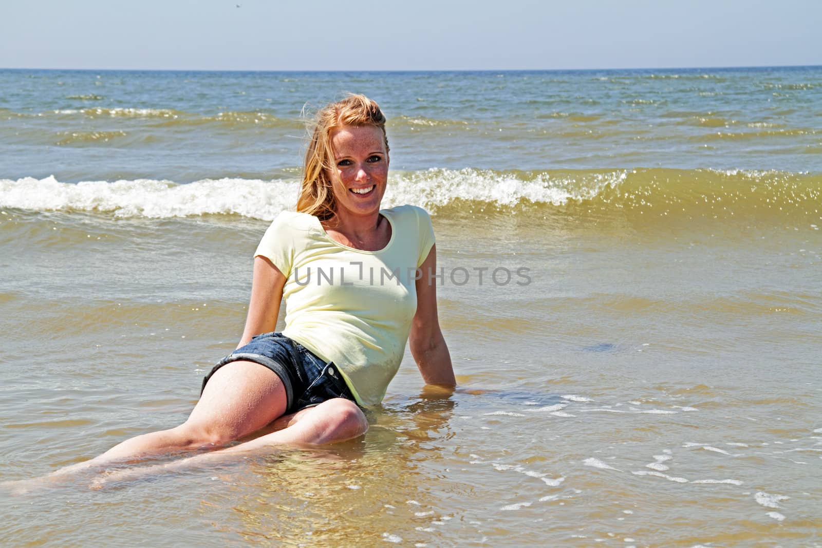 Beautiful woman laying in the ocean in the Netherlands
