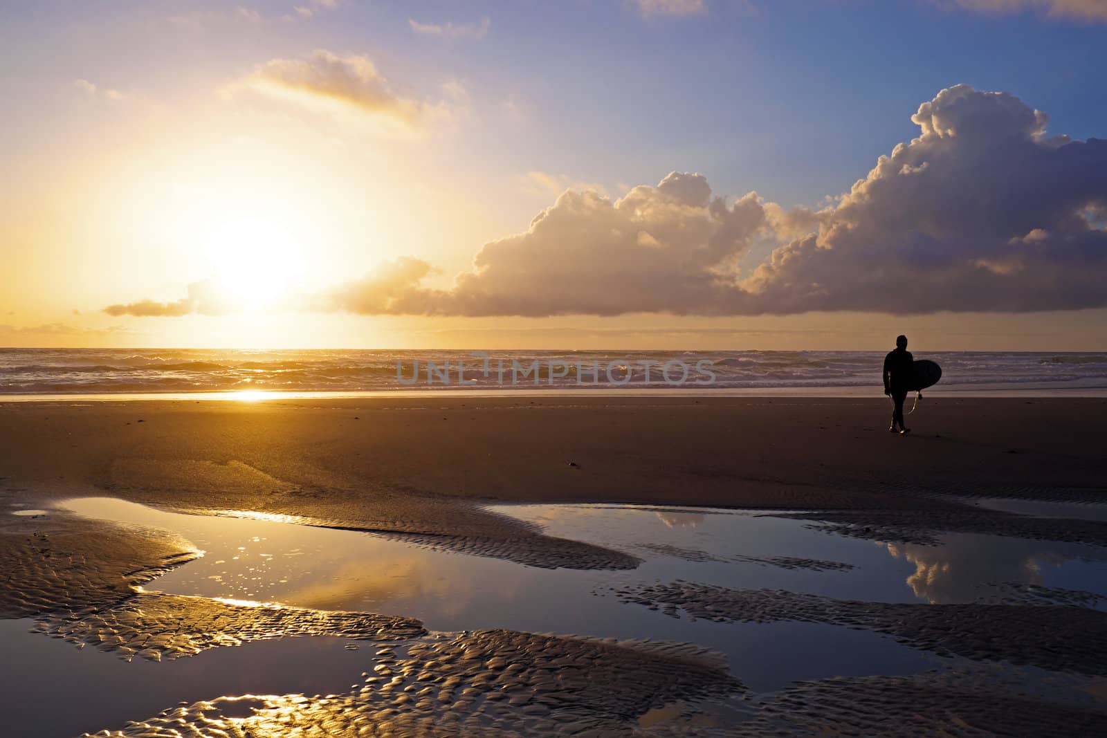 Surfer  at the beach at sunset in Portugal