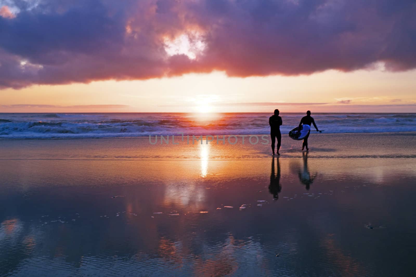 Surferrs at the ocean at sunset in Portugal