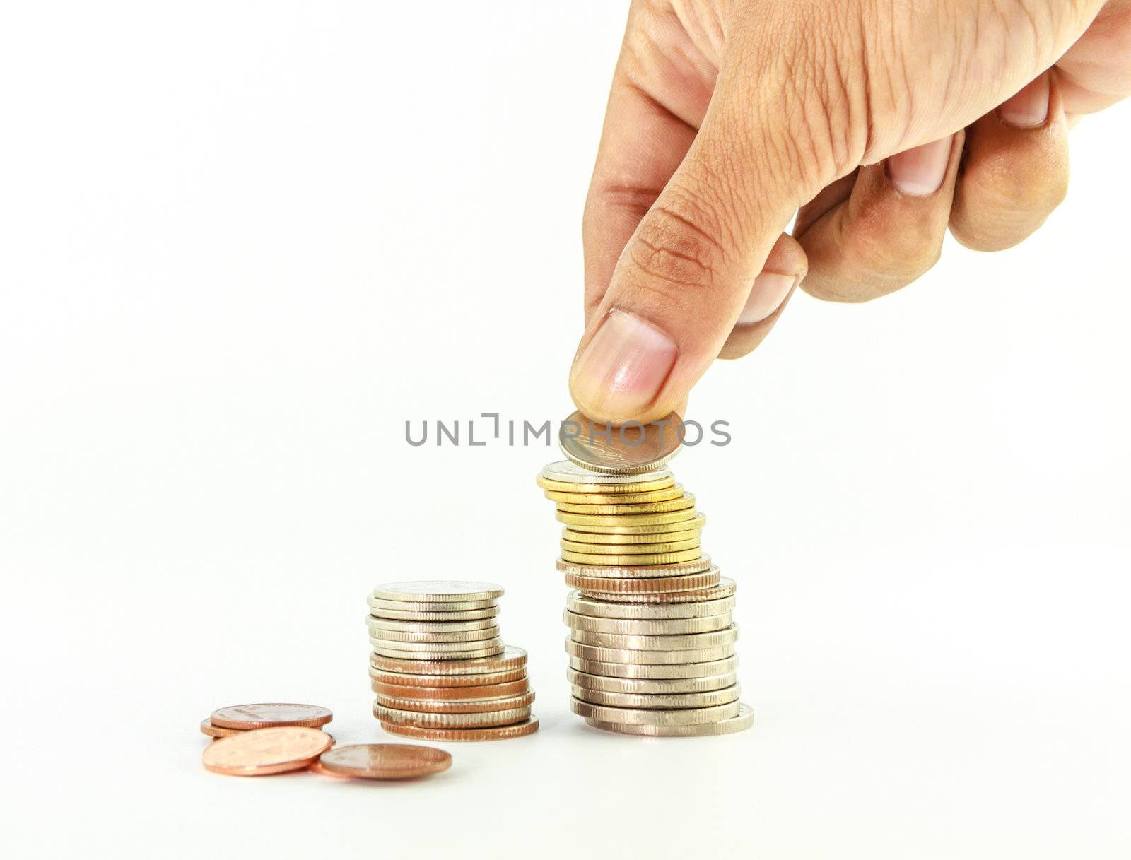 Stack of coins with hand on white background