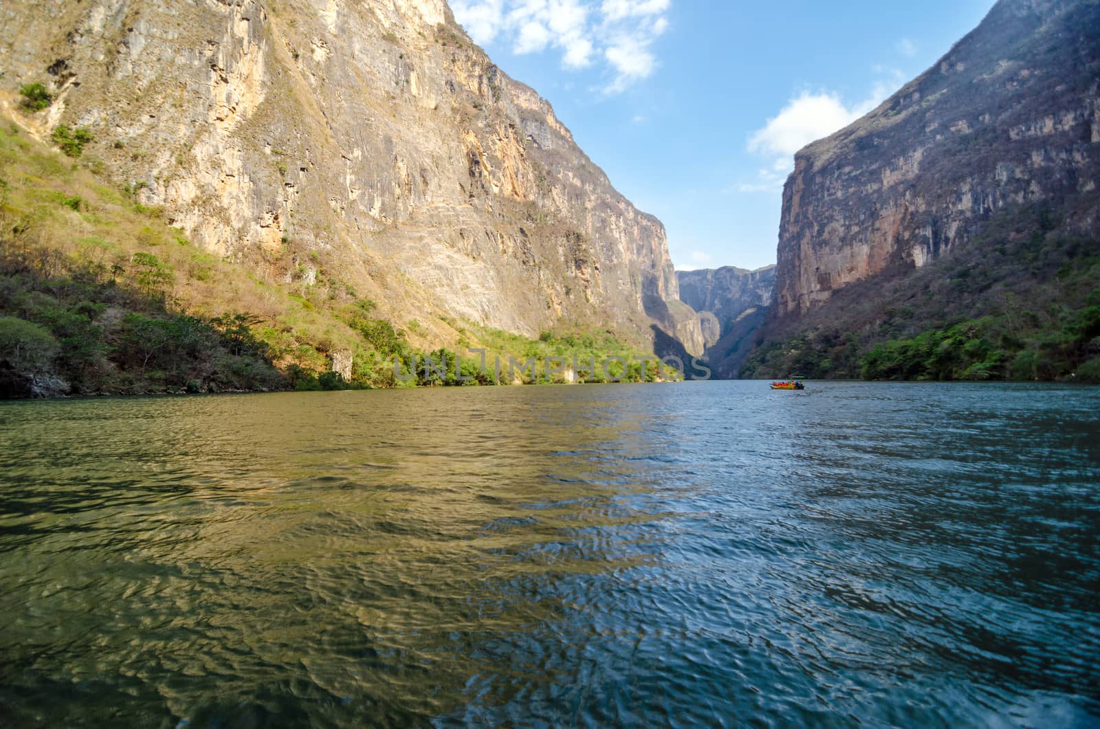 River at the bottom of Sumidero Canyon with a boat in the distance in Chiapas, Mexico