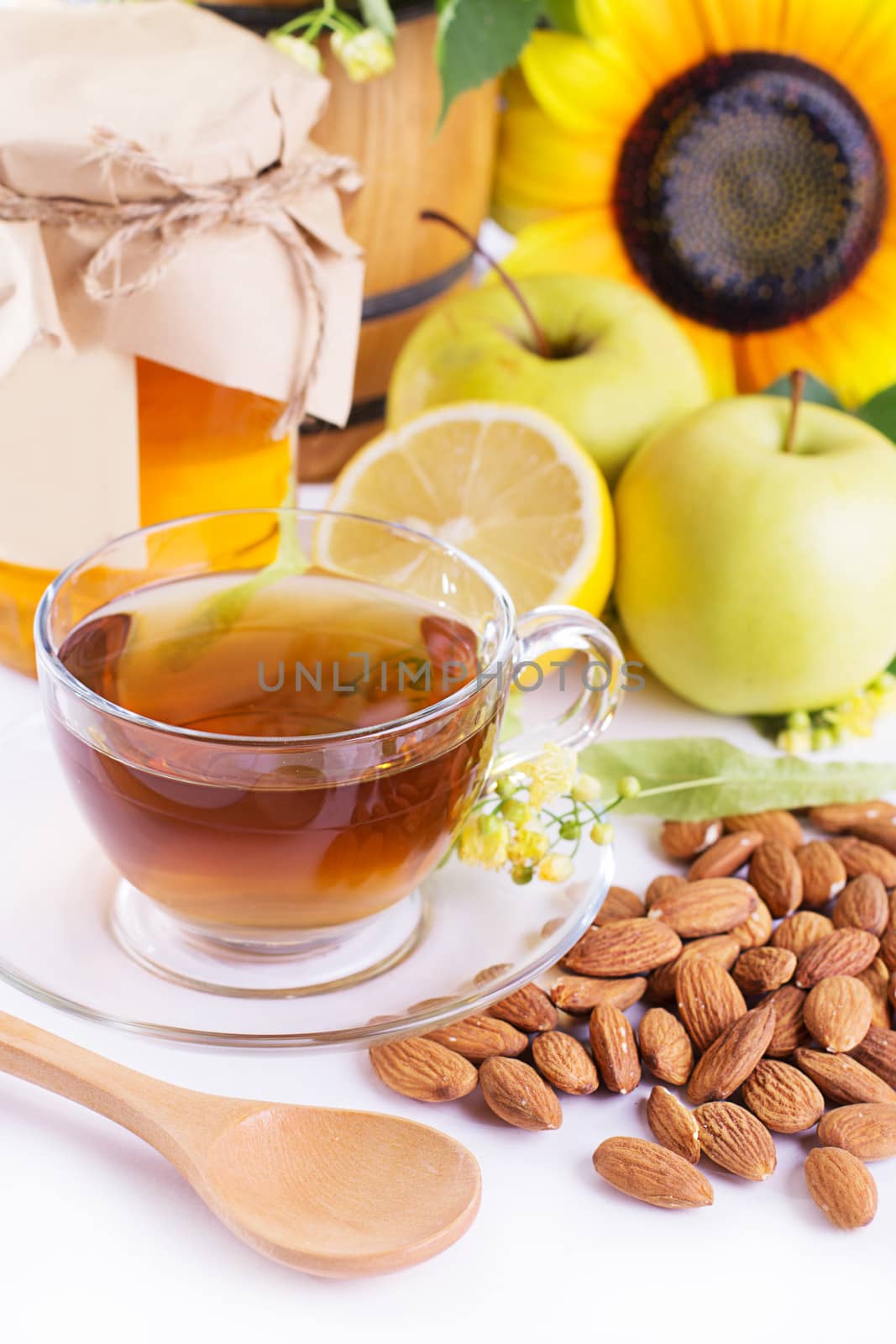 Cup of tea with linden honey, apples, almonds isolated on white