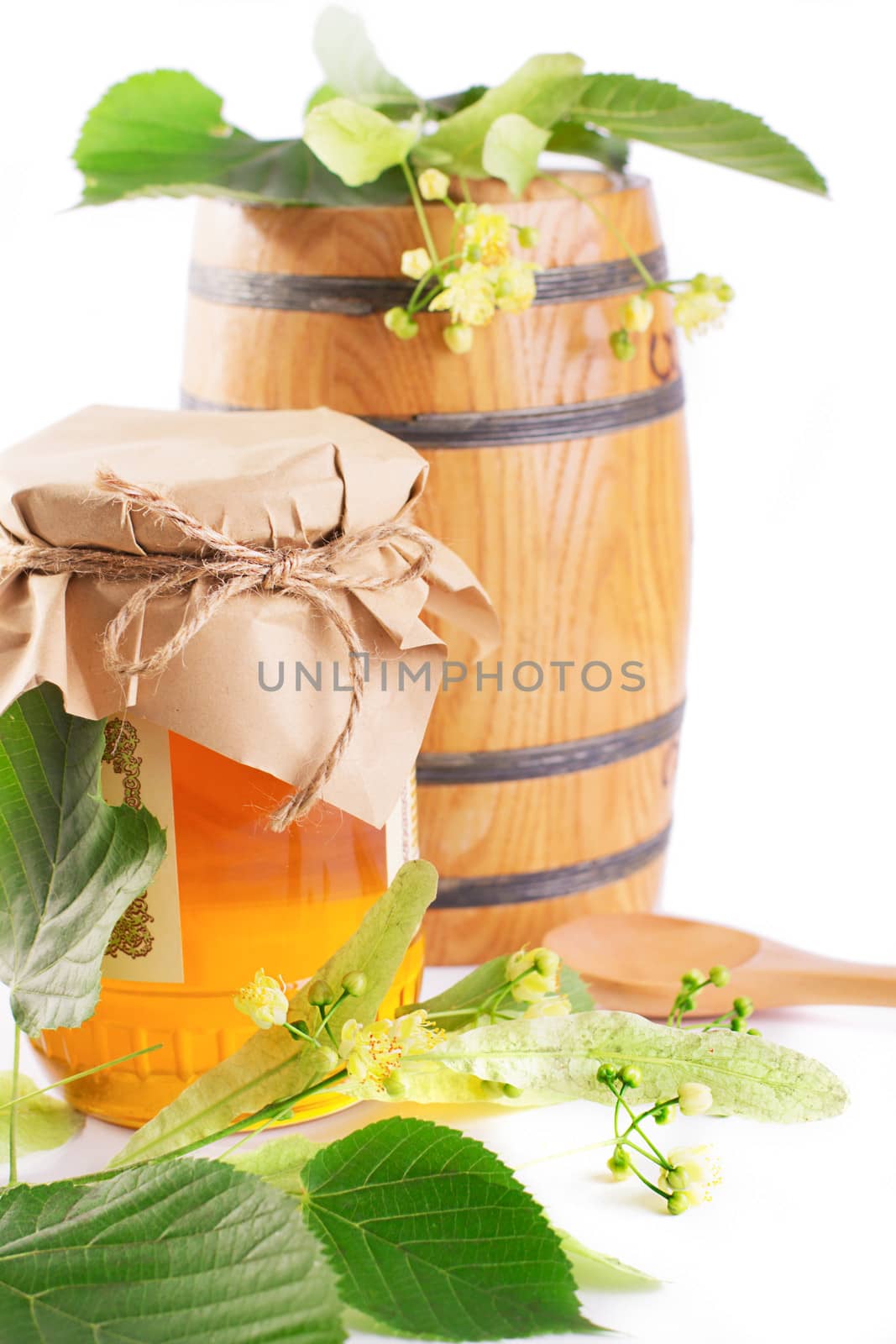 Linden honey jar and barrel with flowers isolated on white