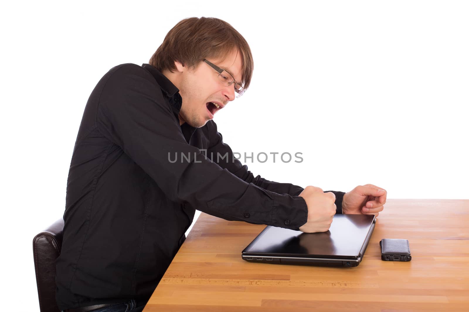 Angry man knock with his fist on his laptop. Isolated on a white background.