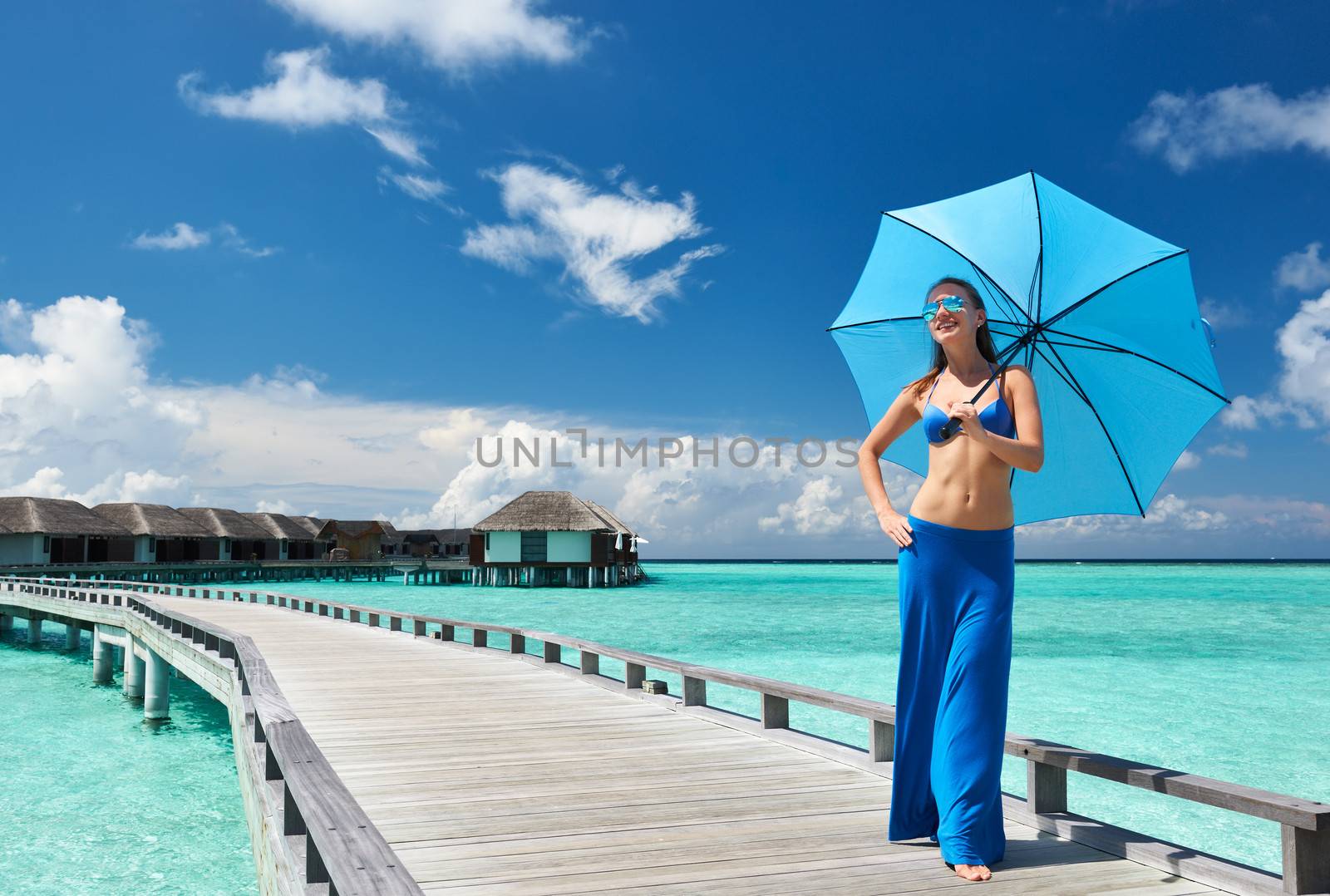 Woman on a tropical beach jetty at Maldives