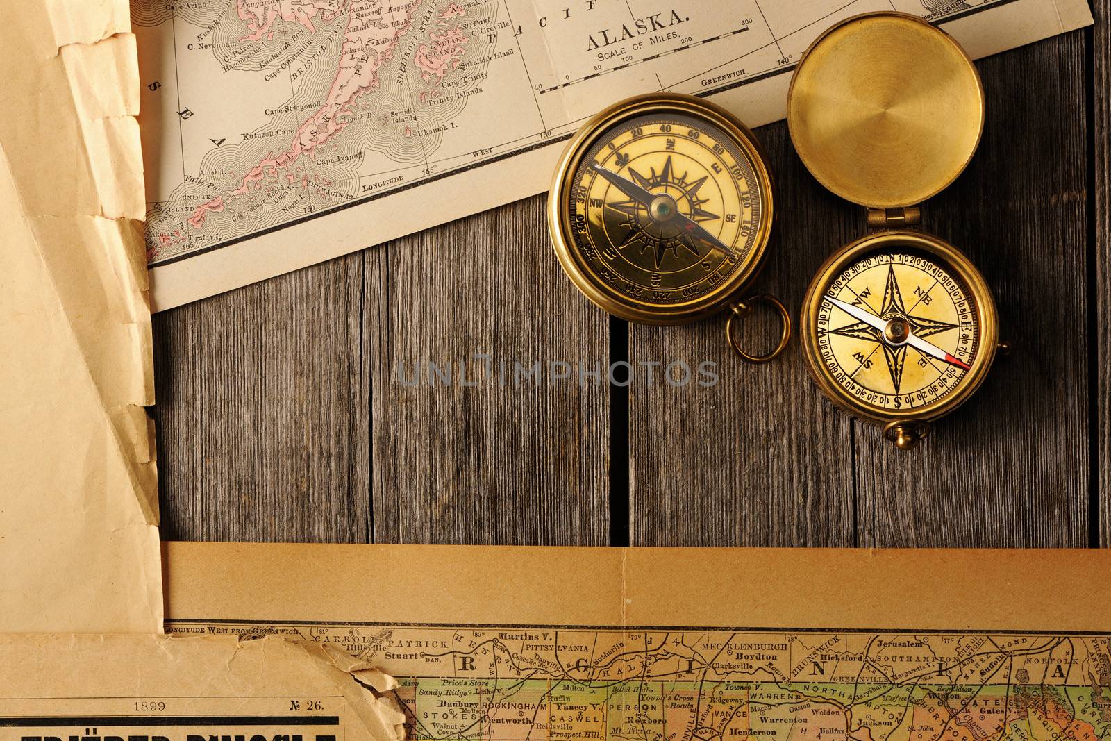 Antique brass compasses over old map