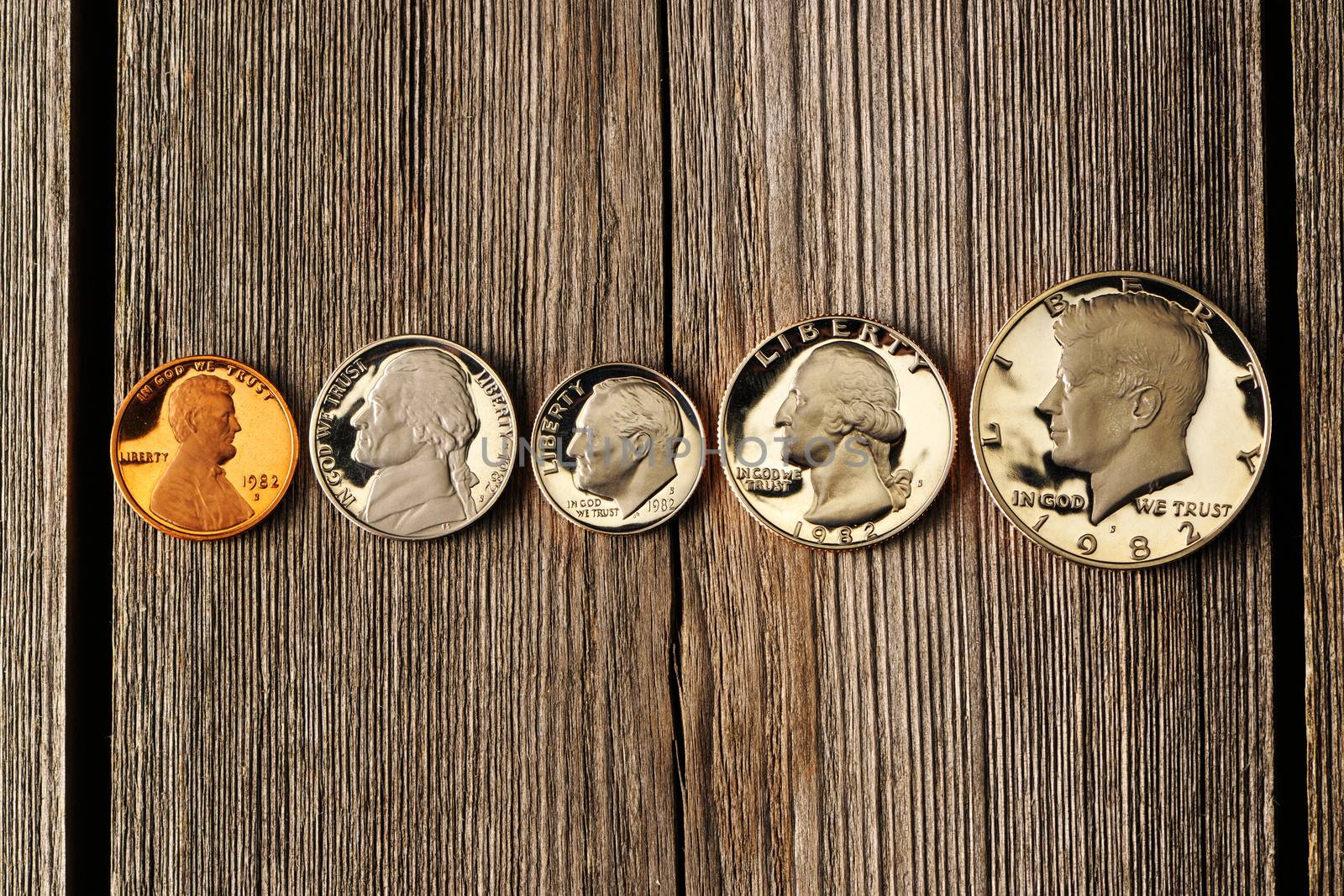 Five US cent coins over wooden background