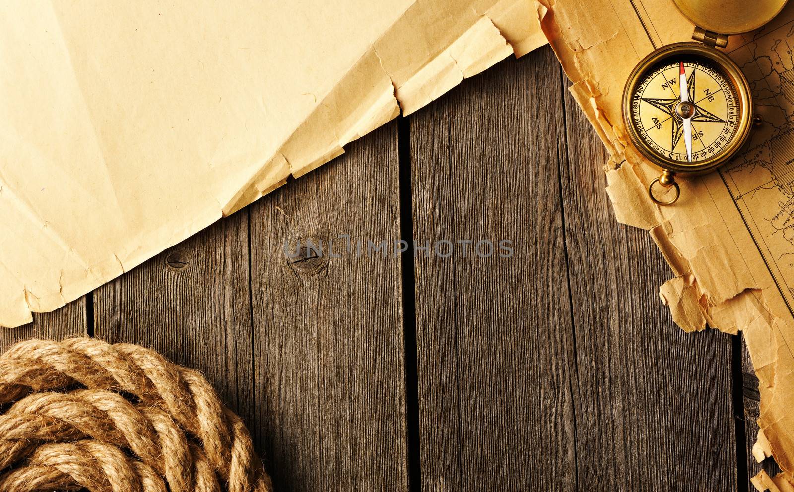 Antique brass compass and rope over old map