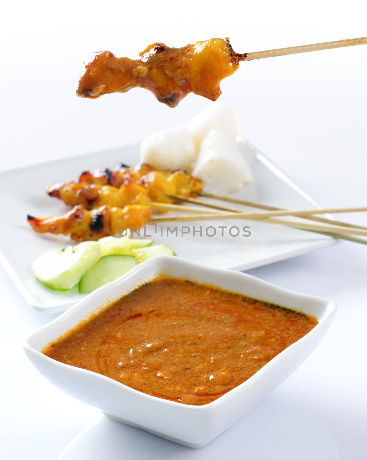 Chicken satay, grilled and skewered meat, served with peanut sauce, cucumber and ketupat. Traditional Malay food. Delicious hot and spicy Malaysian dish, Asian cuisine.