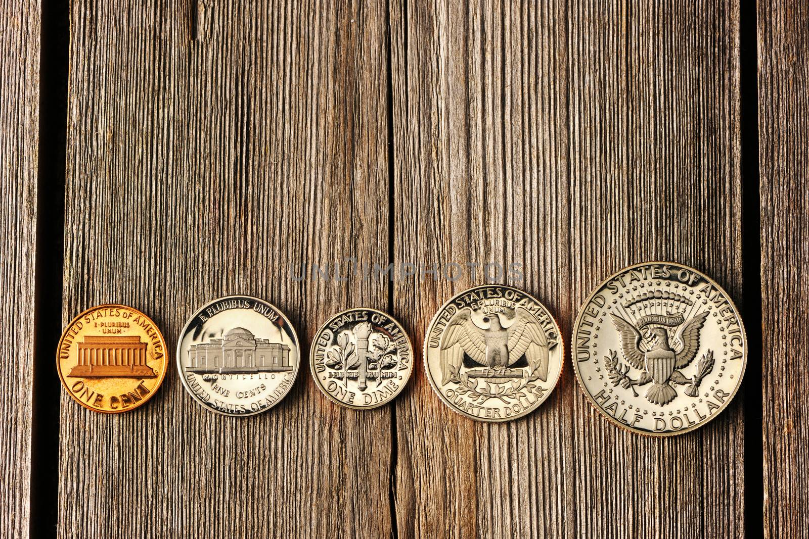 Five US cent coins over wooden background