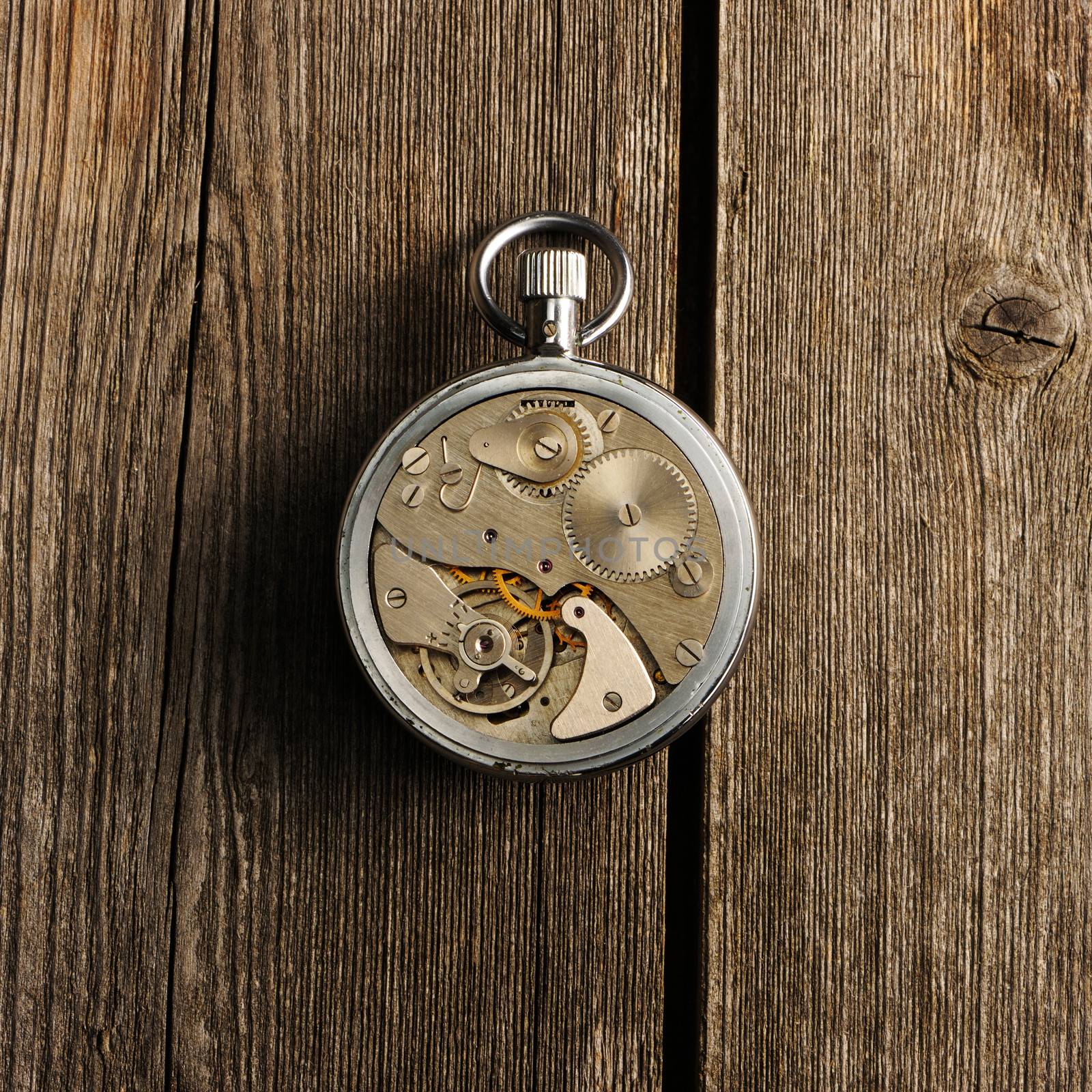 Clockwork mechanism over wooden background 