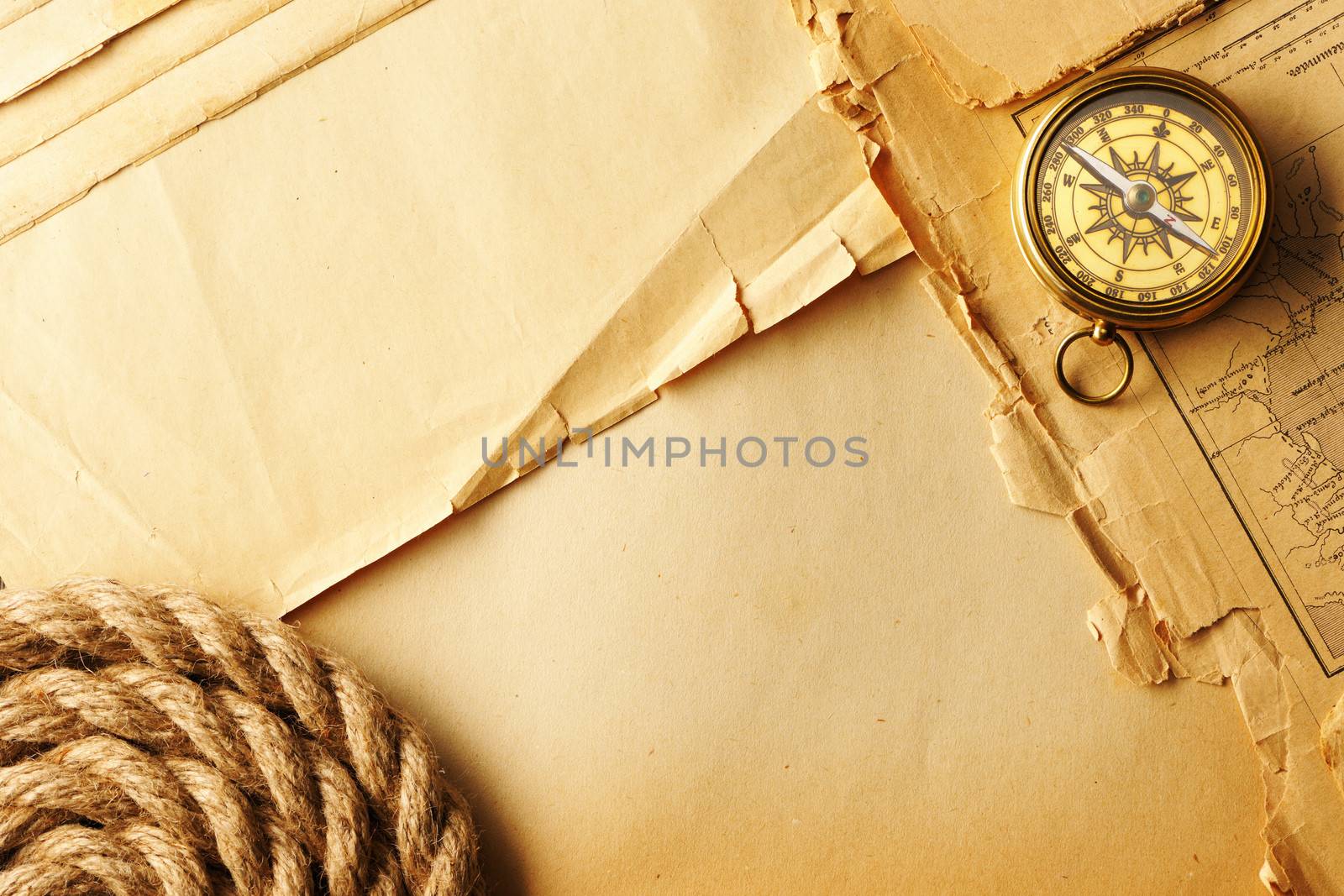 Antique brass compass and rope over old map