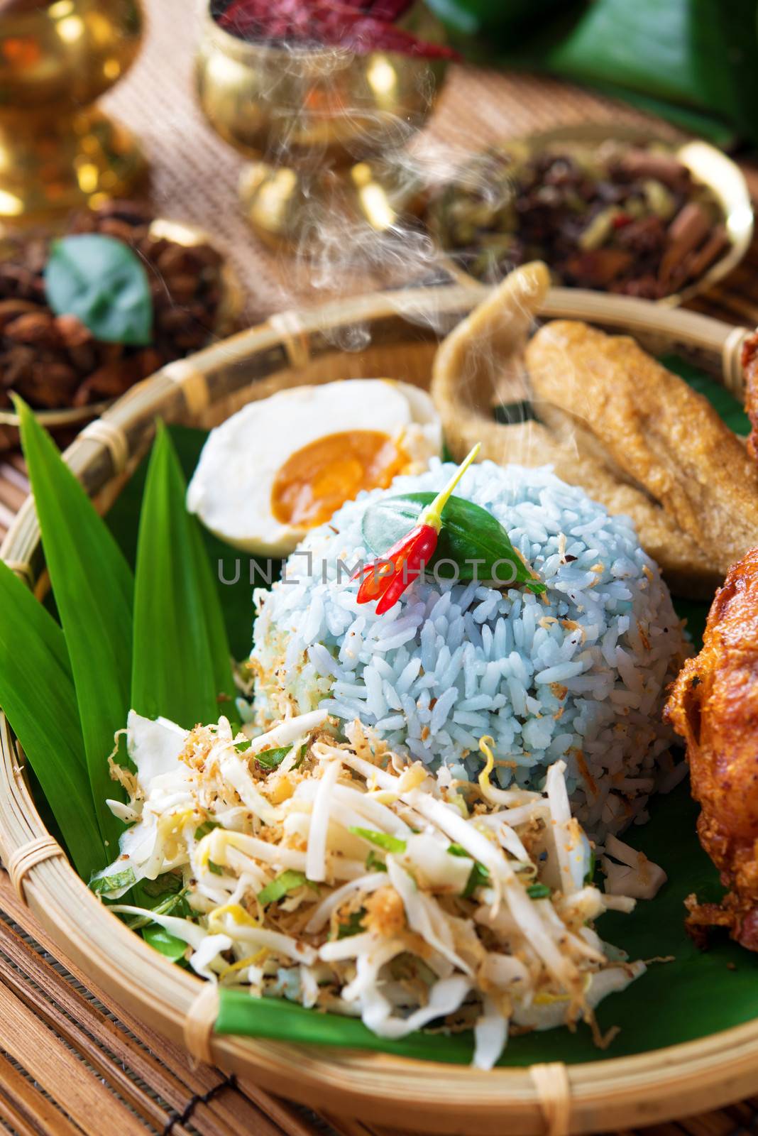 Nasi kerabu is a type of nasi ulam, popular delicious Malay rice dish. Blue color of rice resulting from the petals of  butterfly-pea flowers. Traditional Malaysian food, Asian cuisine.