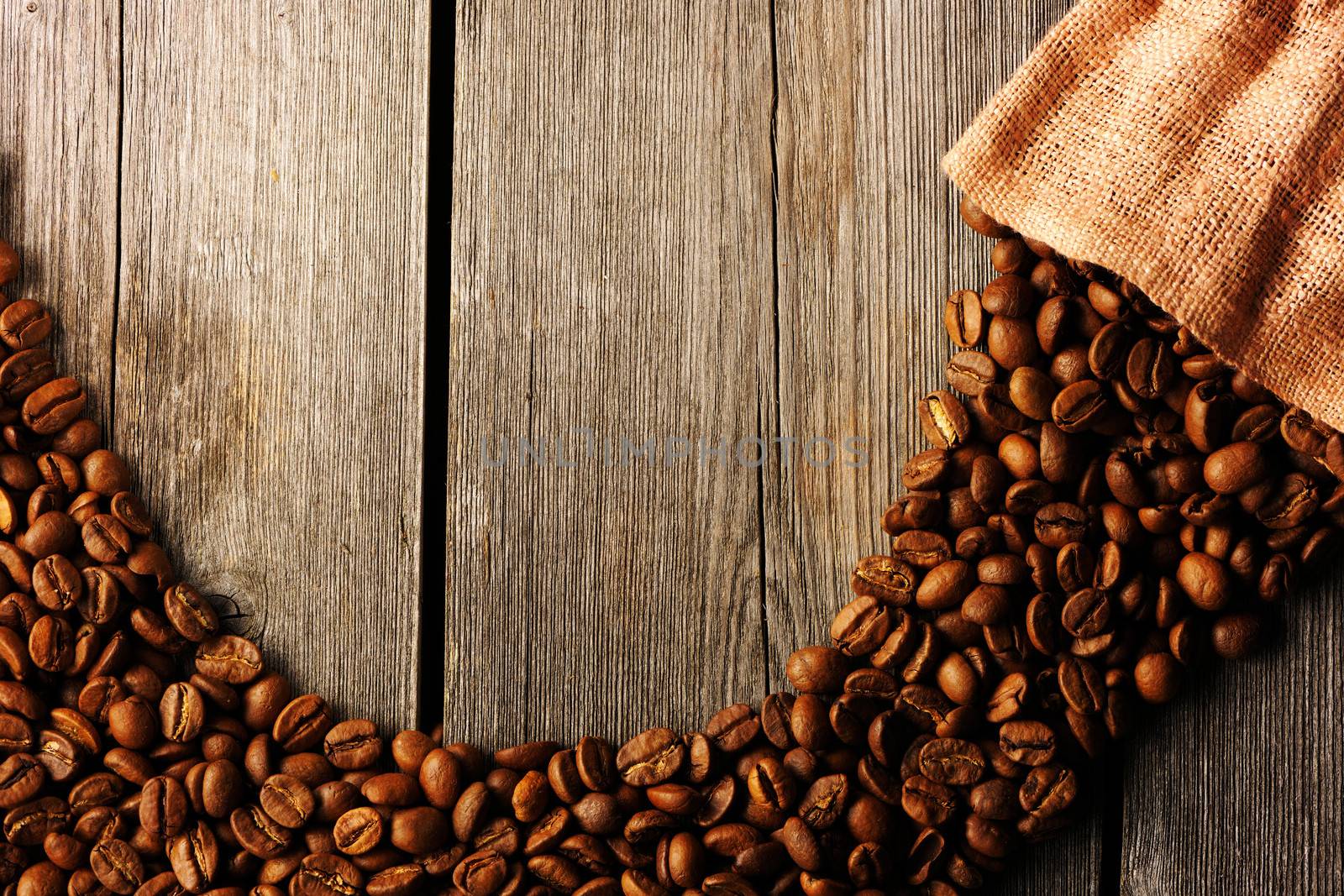 Coffee beans and bag over wooden background