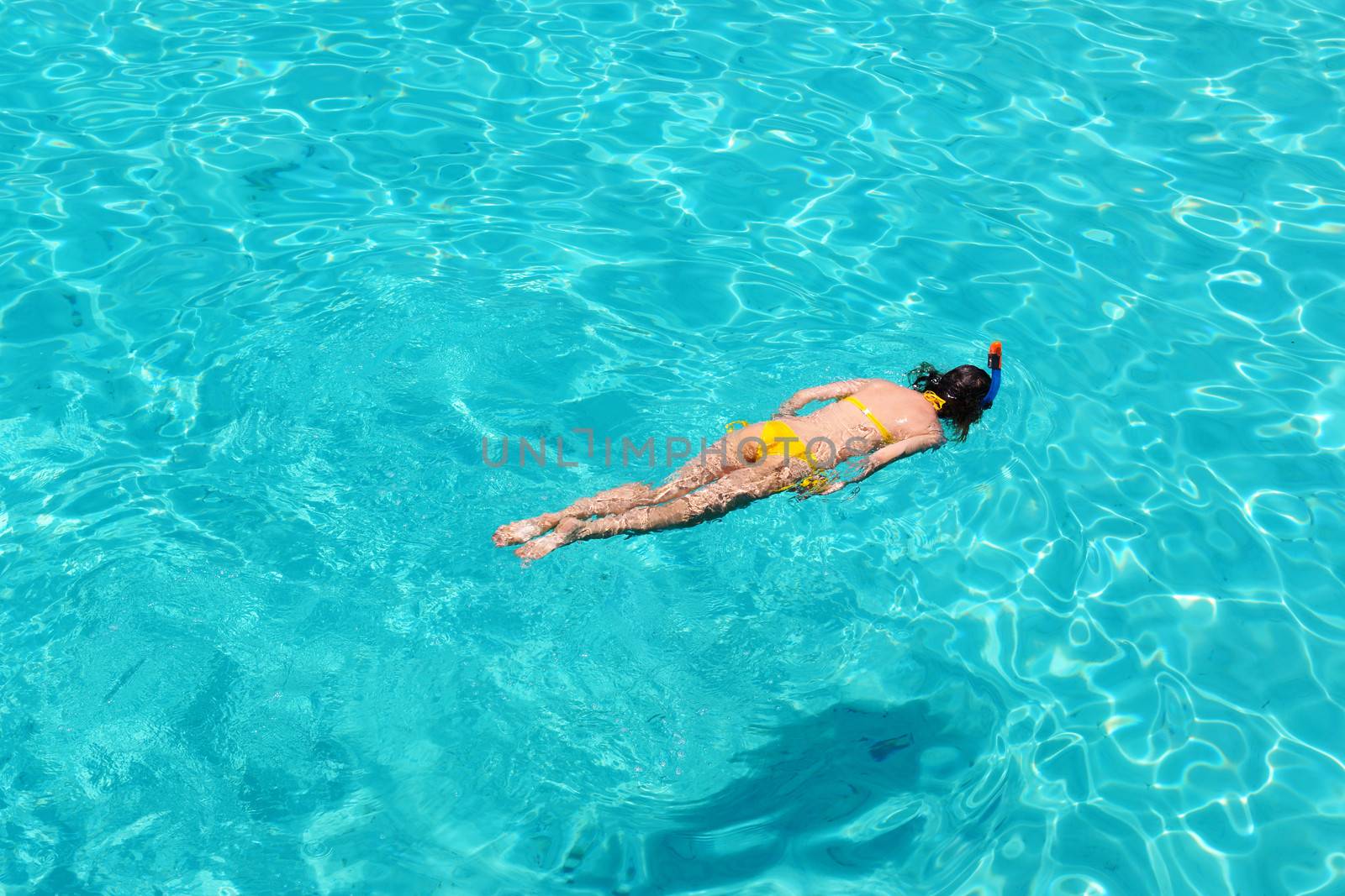 Woman snorkeling in crystal clear turquoise water at tropical beach