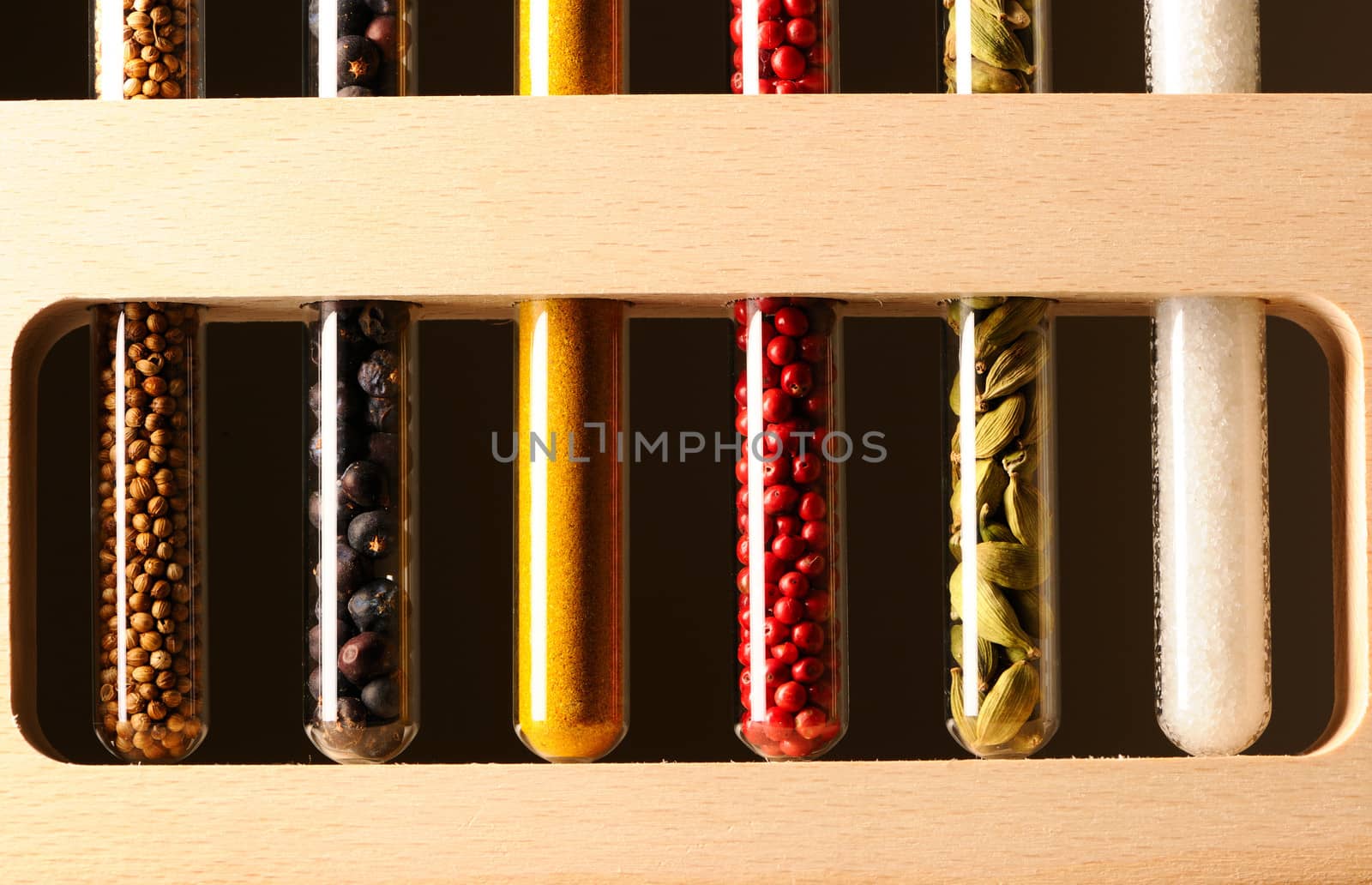 Spices in beakers against dark background