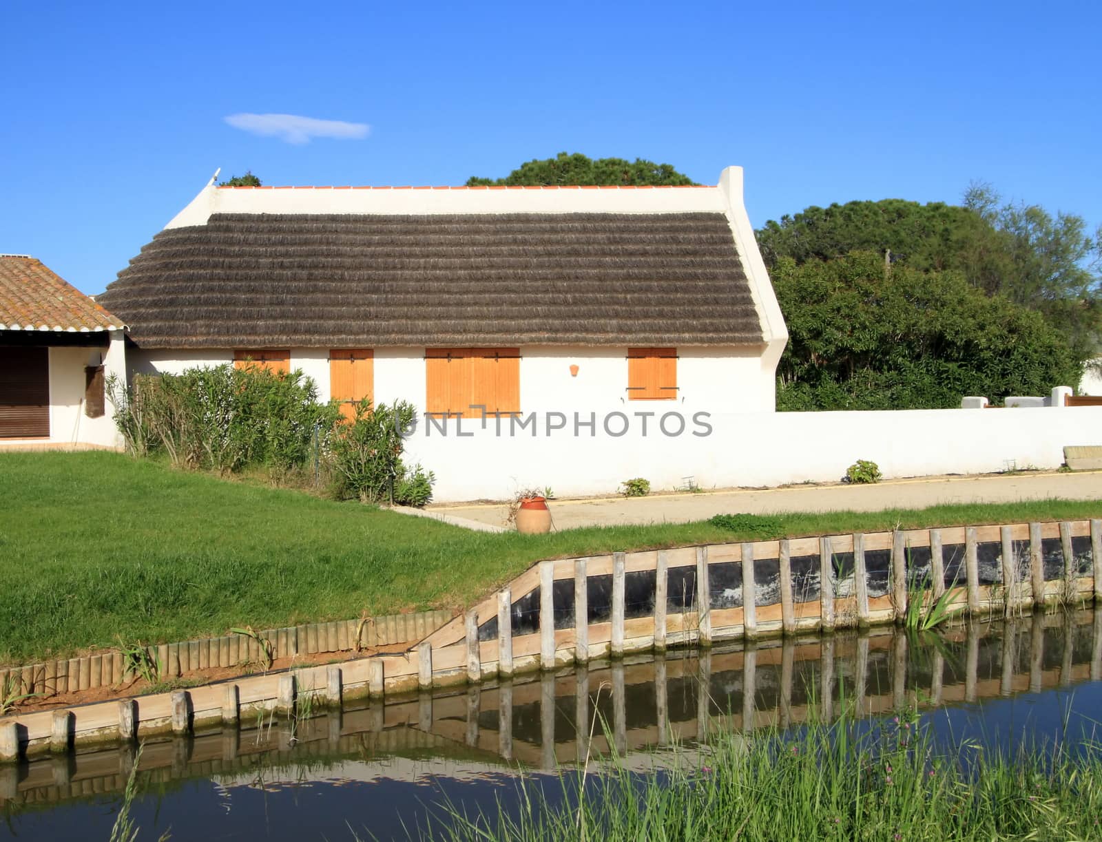 Typical guardian house next to a small water canal by beautiful weather, Camargue, France