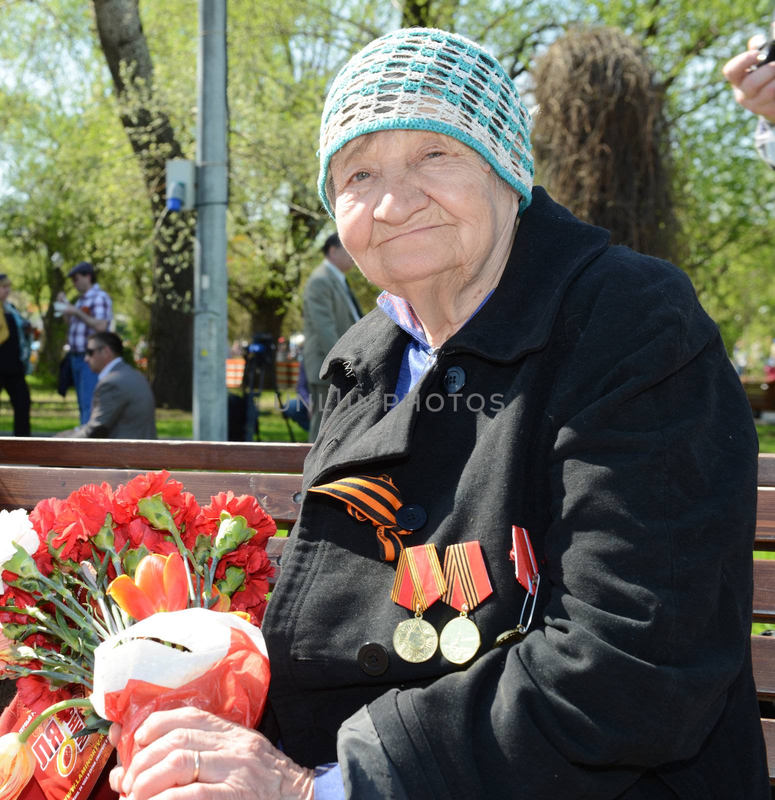  Moscow, Russia - May 9, 2013: Old woman veteran of WWII  bearing bunch of flowers during festivities devoted to 68th anniversary of Victory Day.
