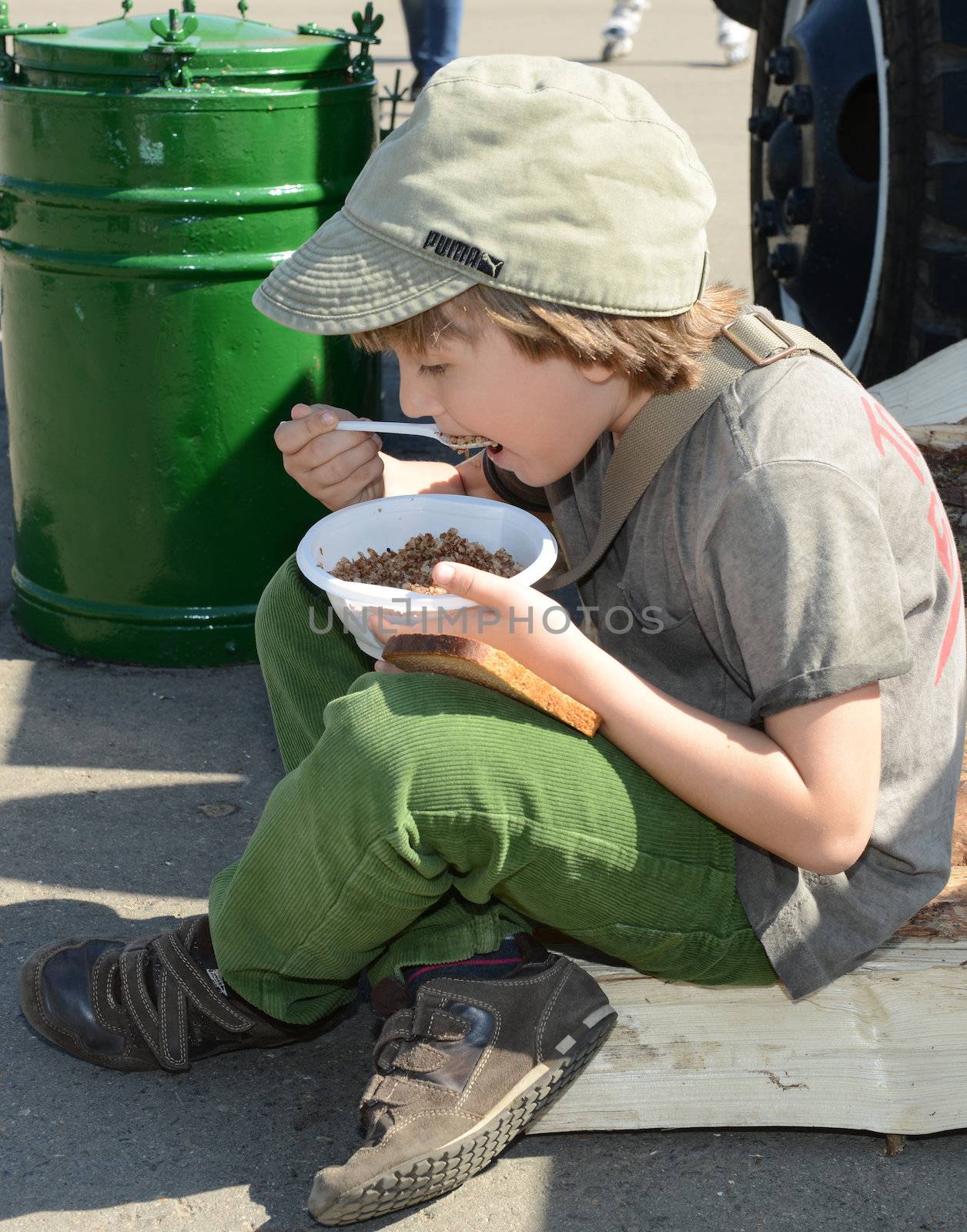  Moscow, Russia - May 9, 2013: Boy eating porridge soldier in the military field kitchen during festivities devoted to 68th anniversary of Victory Day