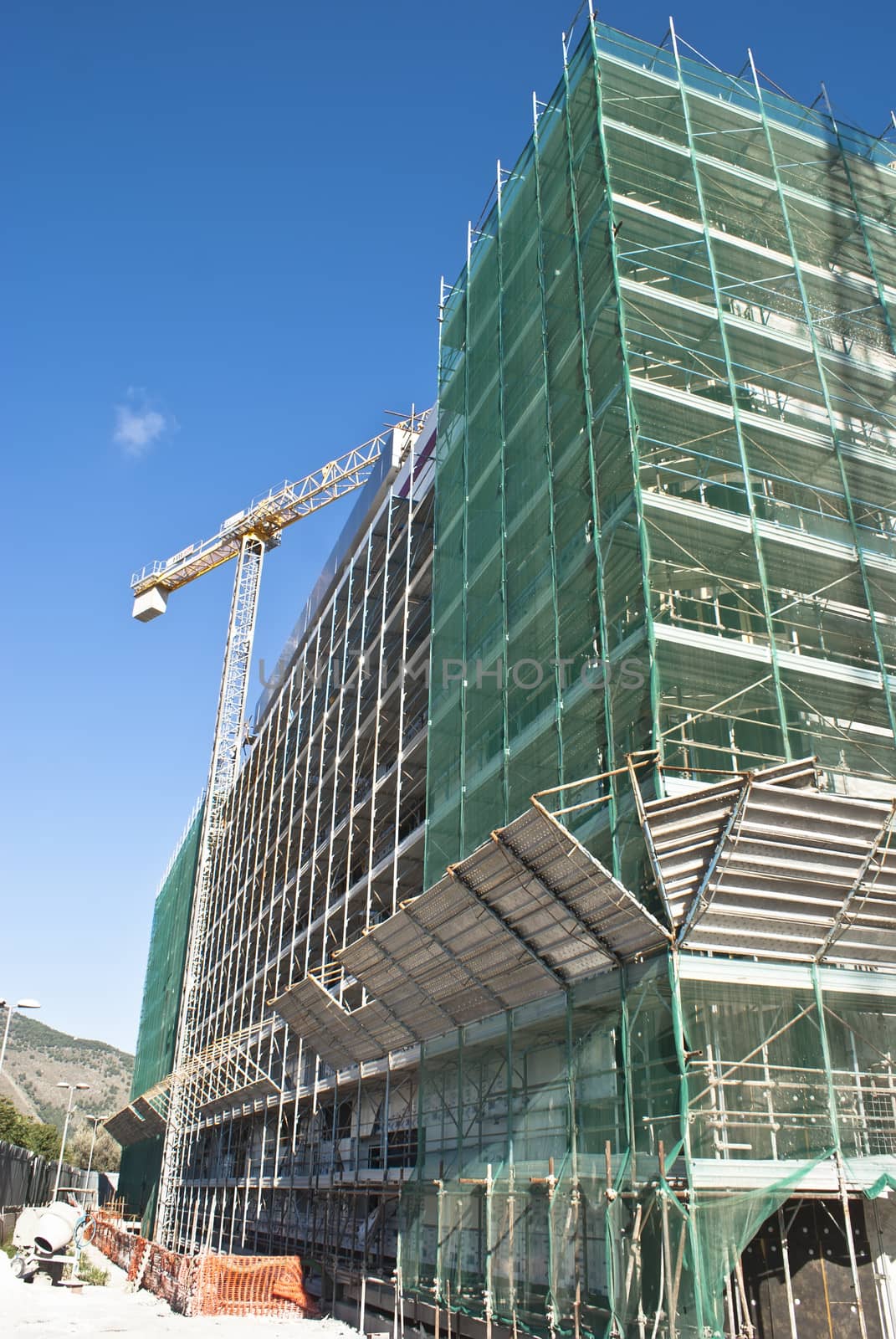 High-rise building construction site with cranes against blue sky