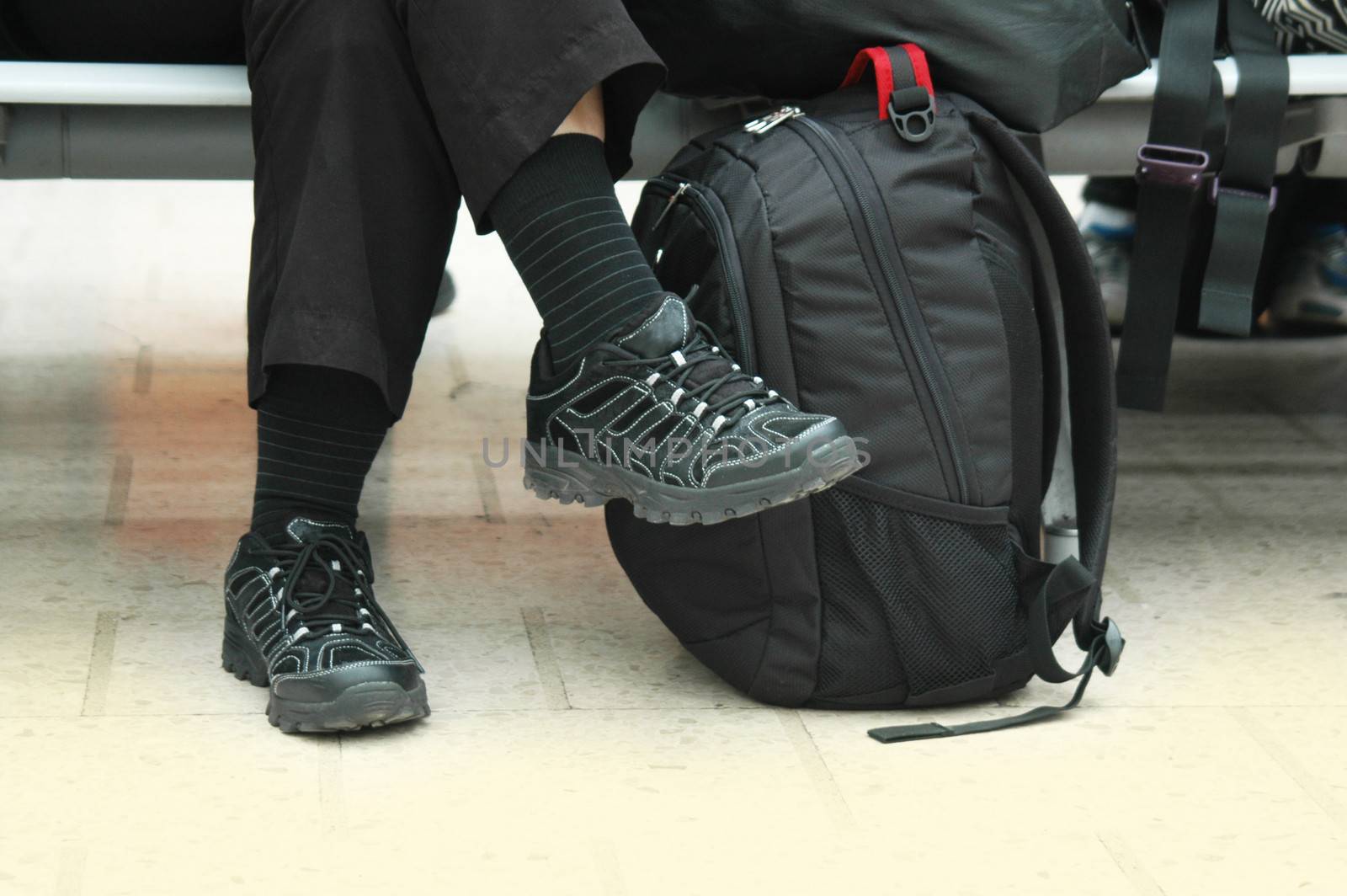 Legs of female tourist near the rucksack