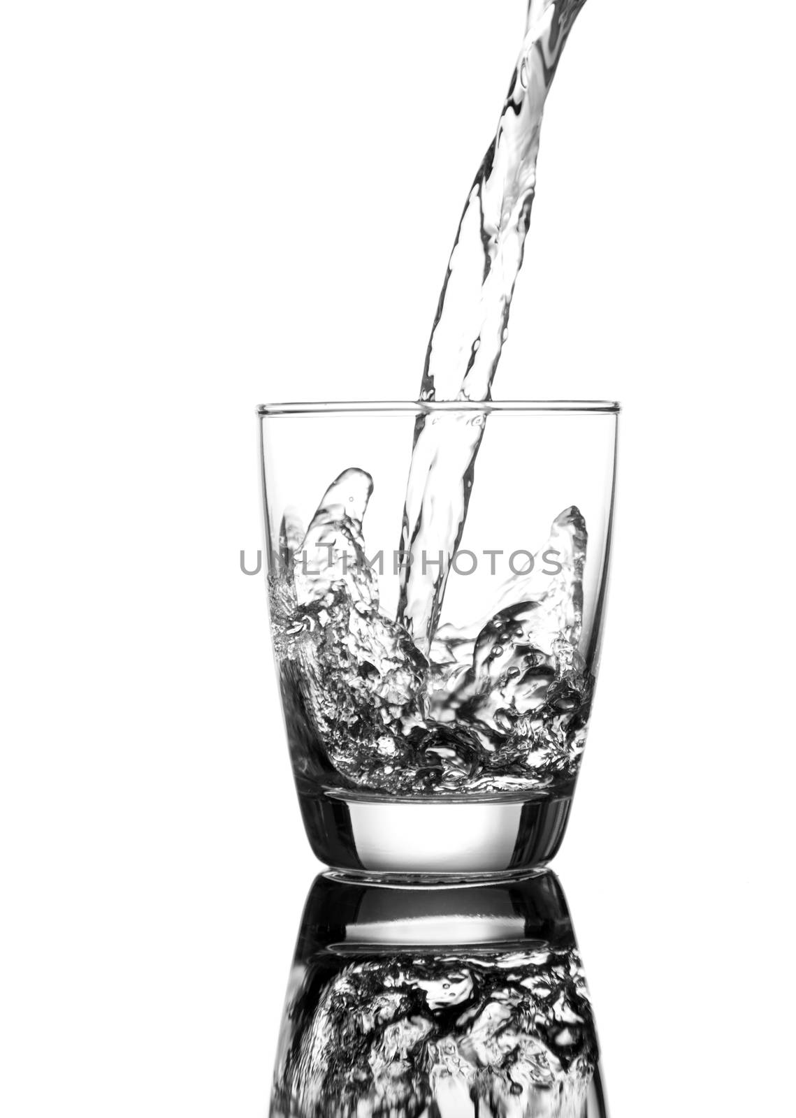 pouring water on a glass on white background by motorolka